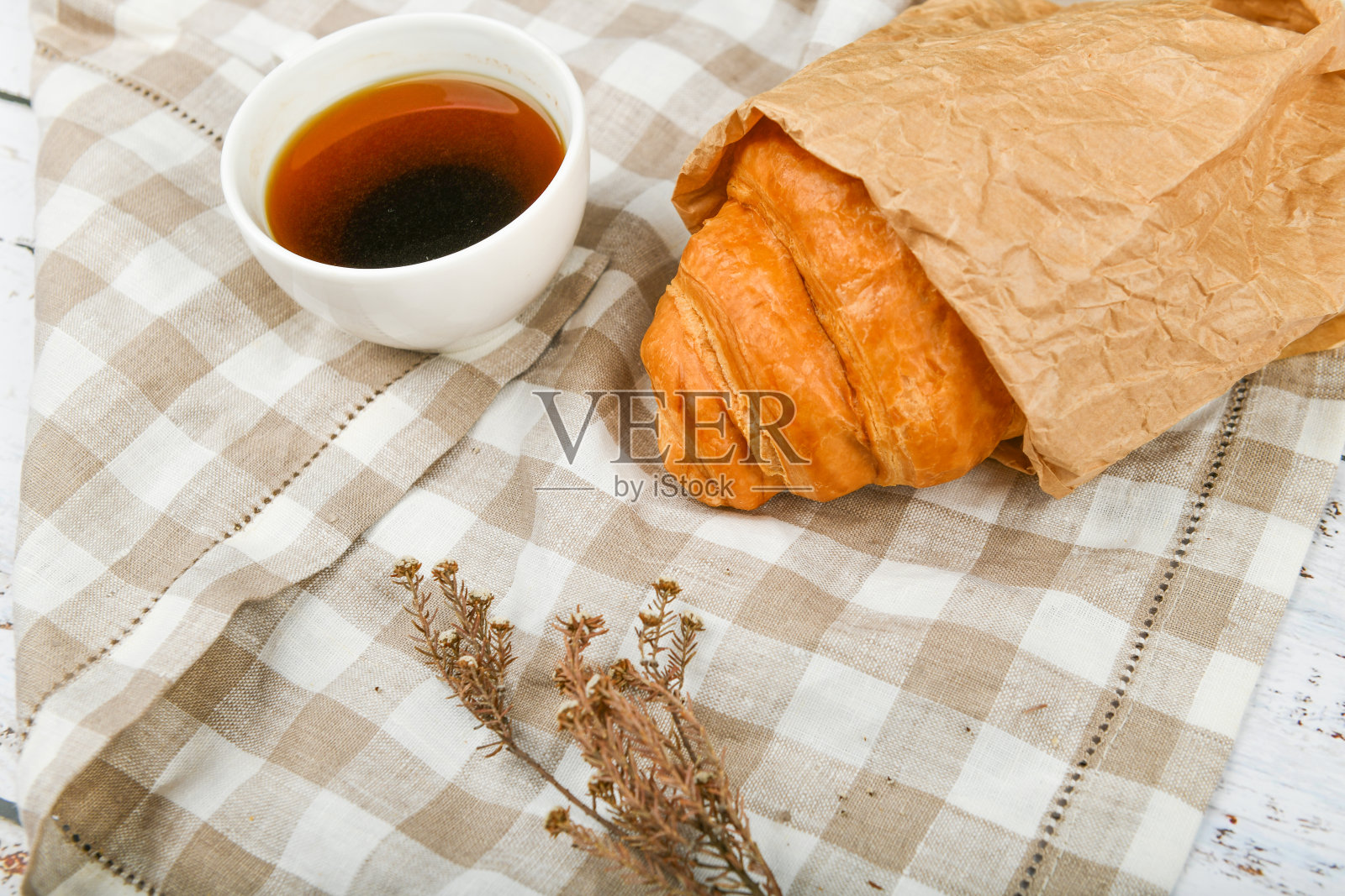 早上吃牛角面包。清晨的开始。新的法国羊角面包。木质背景上放着咖啡杯和新鲜烘焙的羊角面包。从以上观点。早餐有羊角面包和咖啡照片摄影图片