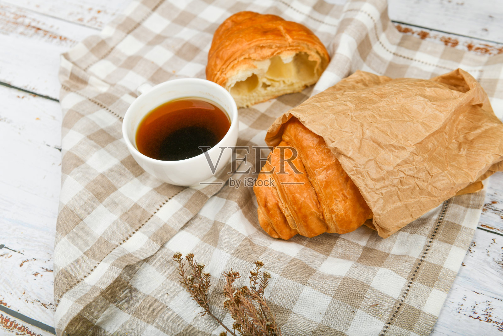早餐,羊角面包。清晨的开始。新的法国羊角面包。木质背景上放着咖啡杯和新鲜烘焙的羊角面包。从以上观点。早餐有羊角面包和咖啡照片摄影图片