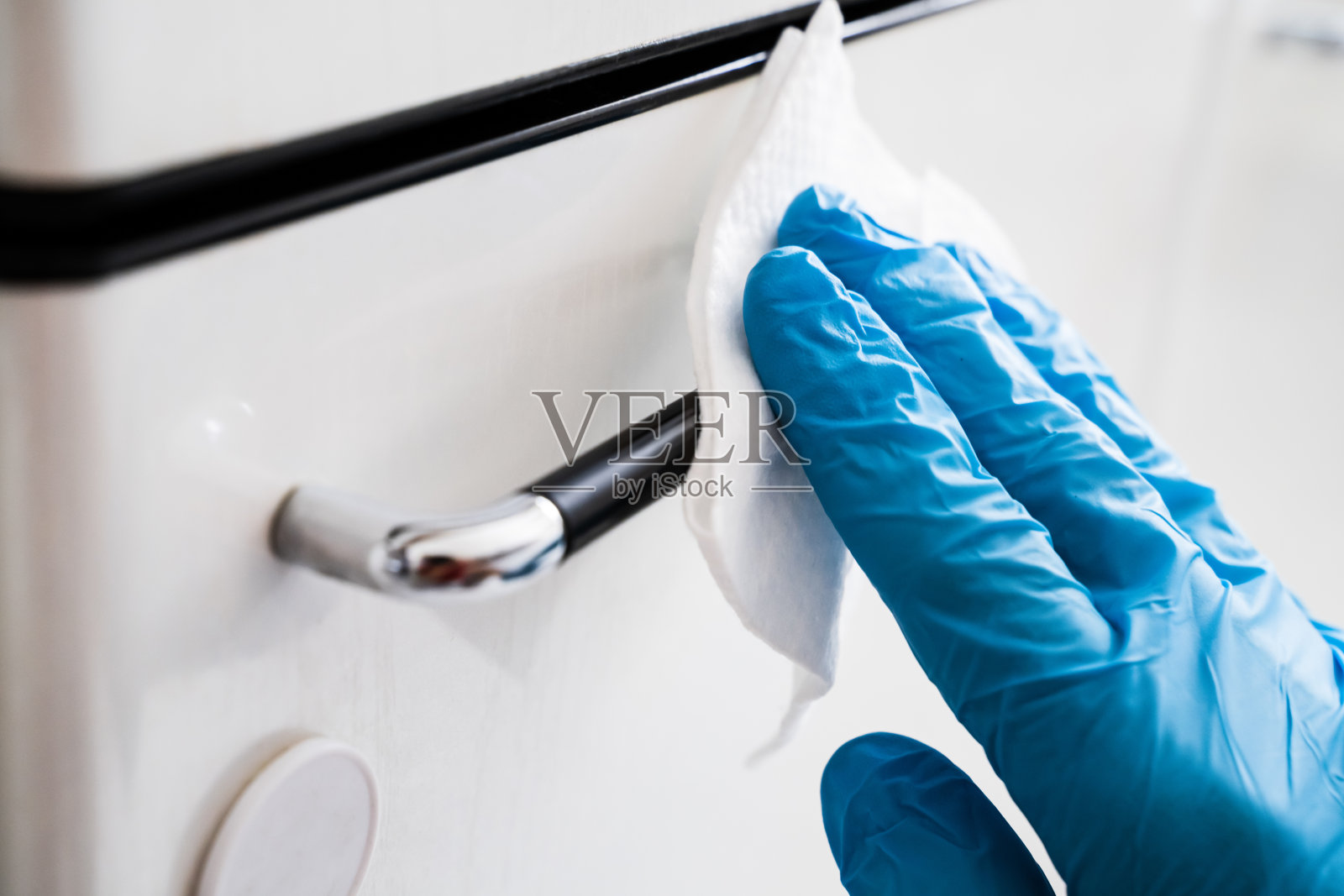 男士用消毒液擦拭橱柜把手照片摄影图片