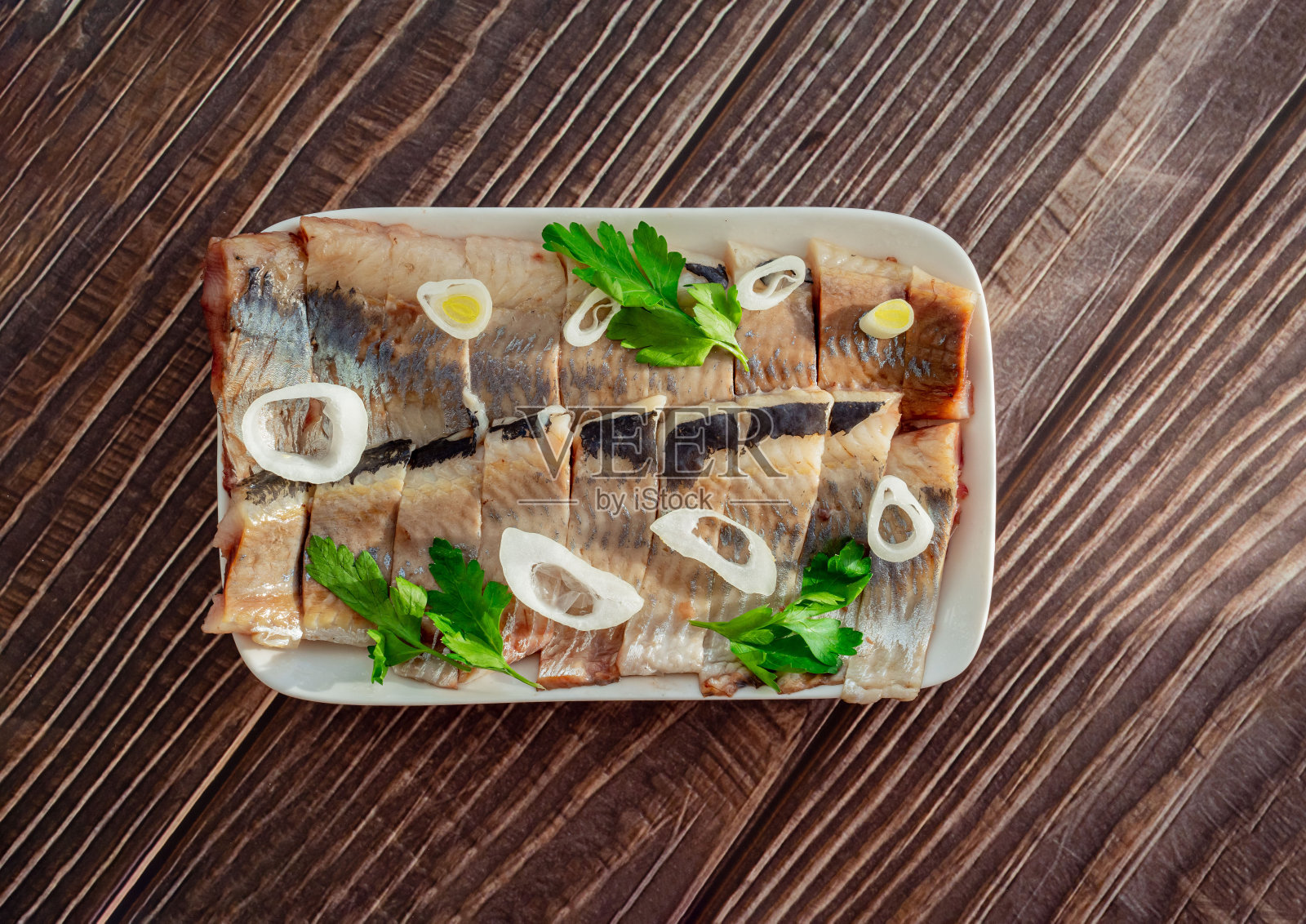 腌鲱鱼切片,白色盘子,洋葱,柠檬照片摄影图片