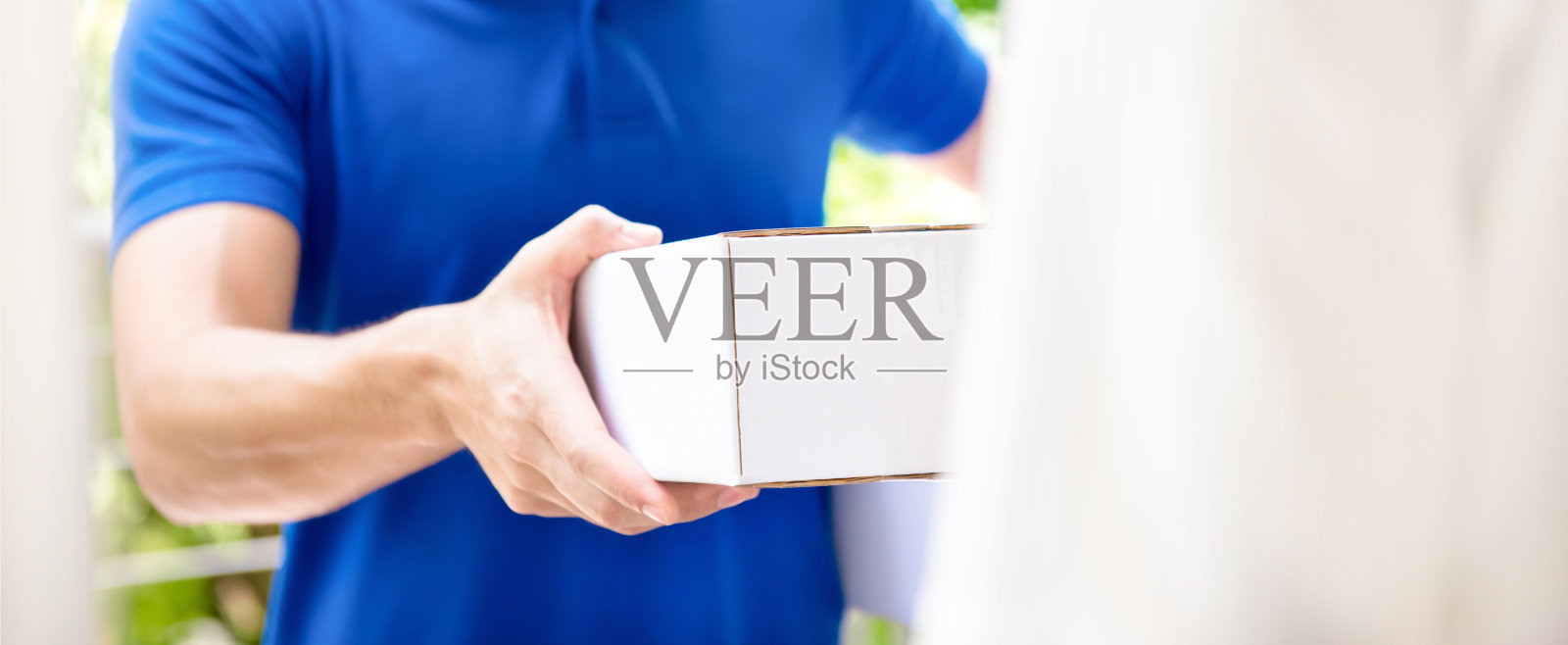 快递员将包裹盒子交给收件人照片摄影图片