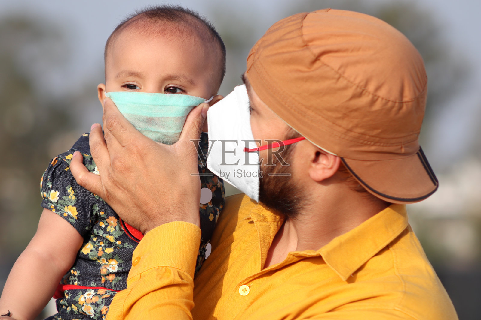 父亲和女婴用口罩遮住脸部,以预防COVID-19或冠状病毒照片摄影图片