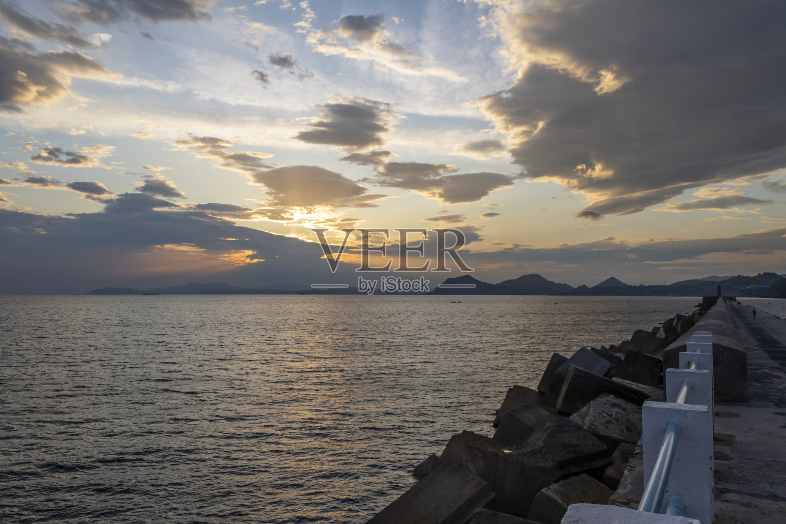 桑坦德防波堤上的日落。照片摄影图片