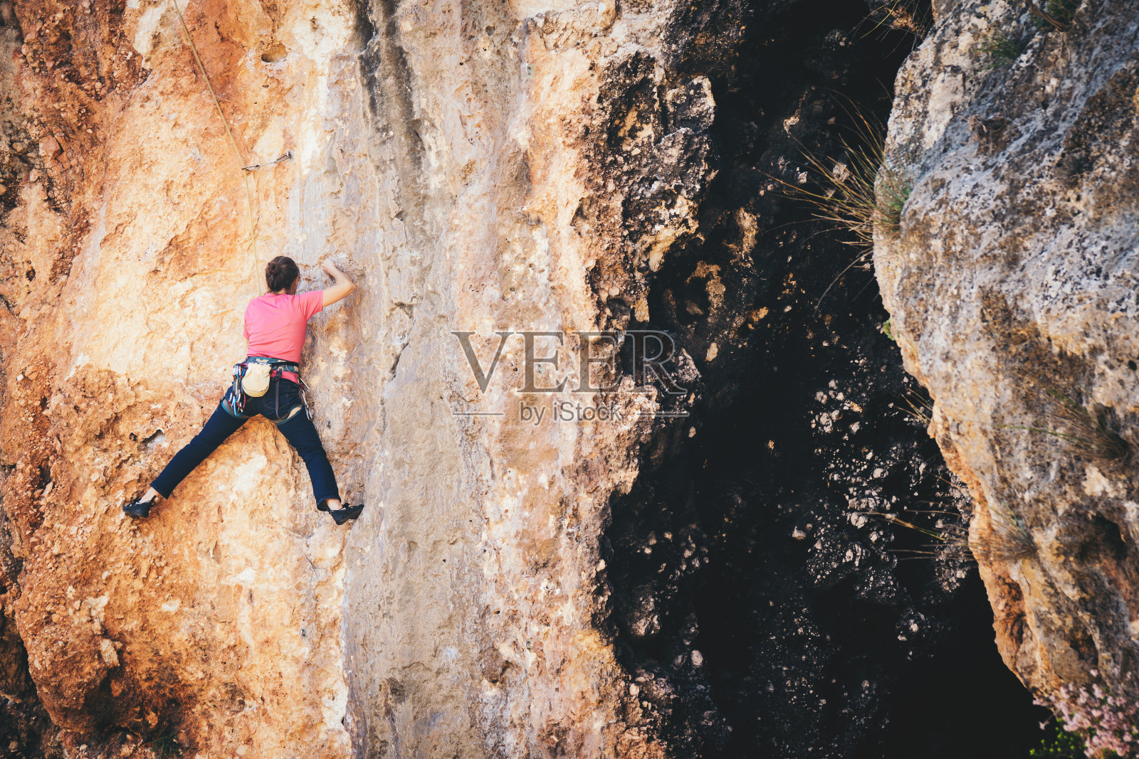 女孩爬岩石。照片摄影图片