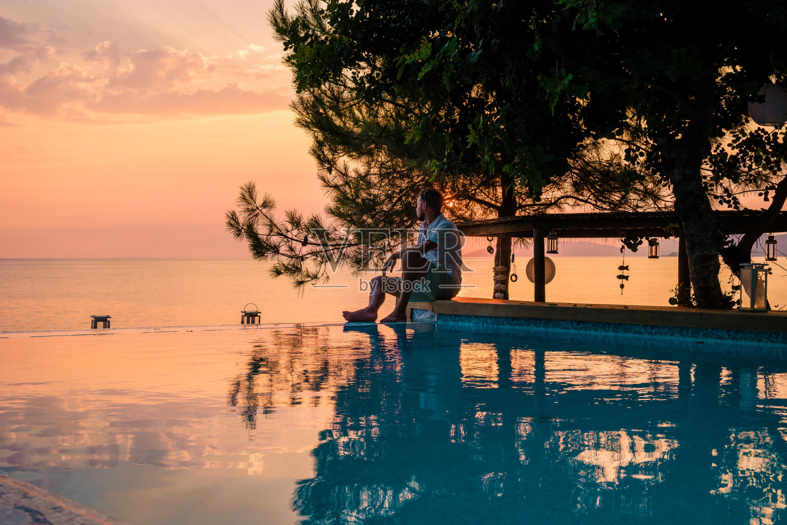 土耳其,年轻男子在游泳池边短距离观看日落,中年男子在土耳其的游泳池边度假照片摄影图片