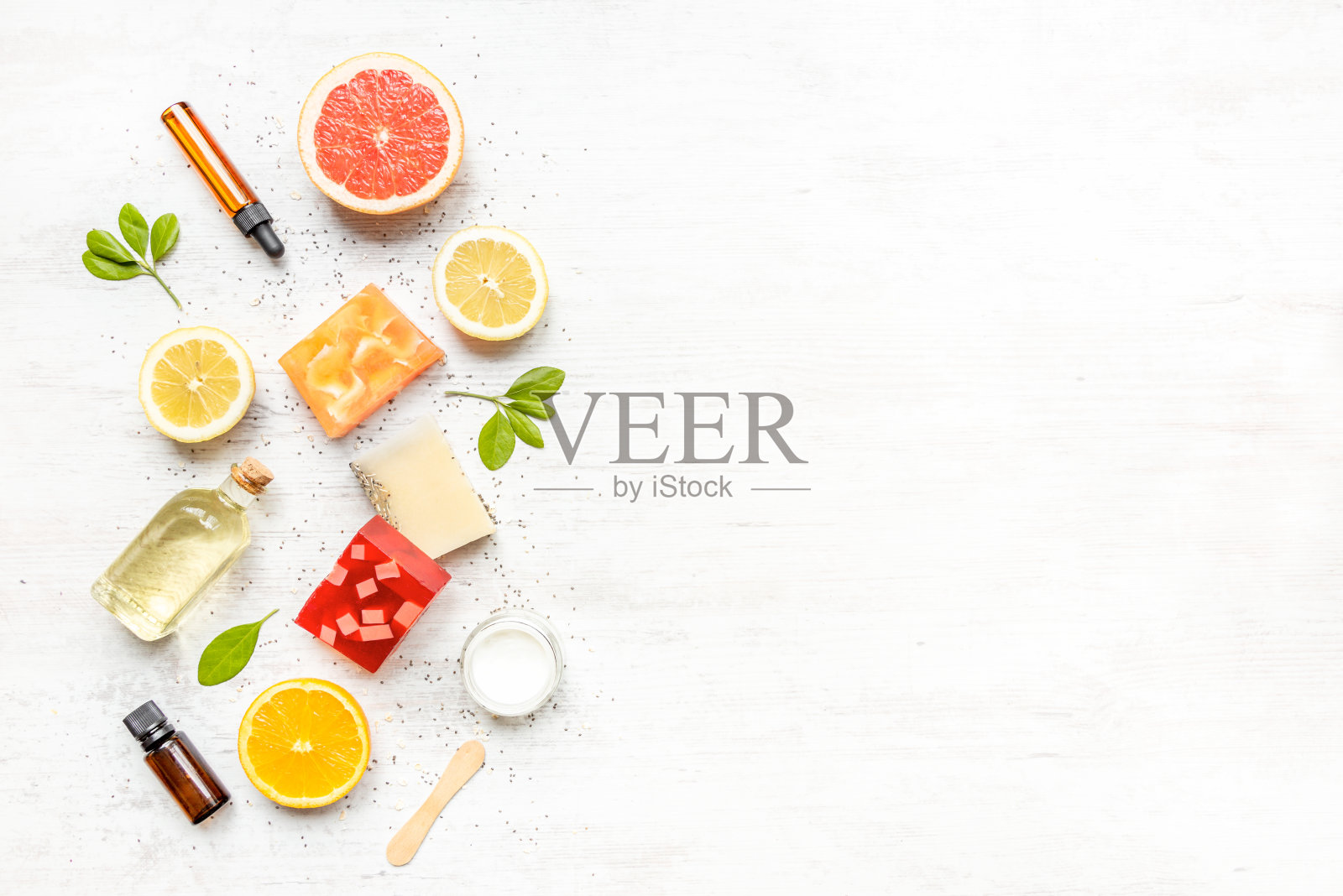 俯视图手工有机肥皂和化妆品与柑橘类水果,草药,奇亚种子和精油排列。白色乡村背景,复制空间。照片摄影图片