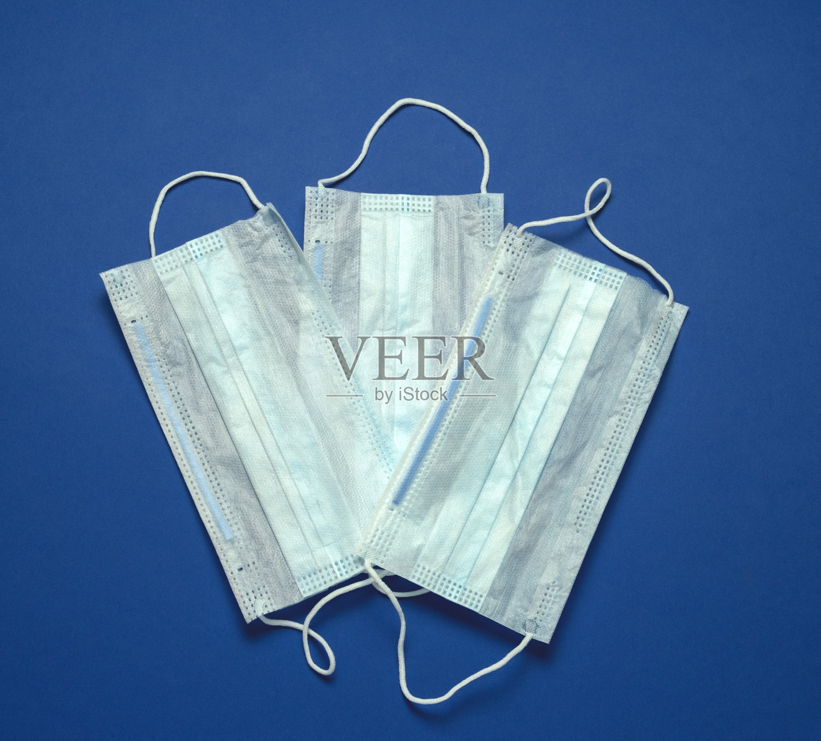 蓝色背景上的医用口罩布局照片摄影图片