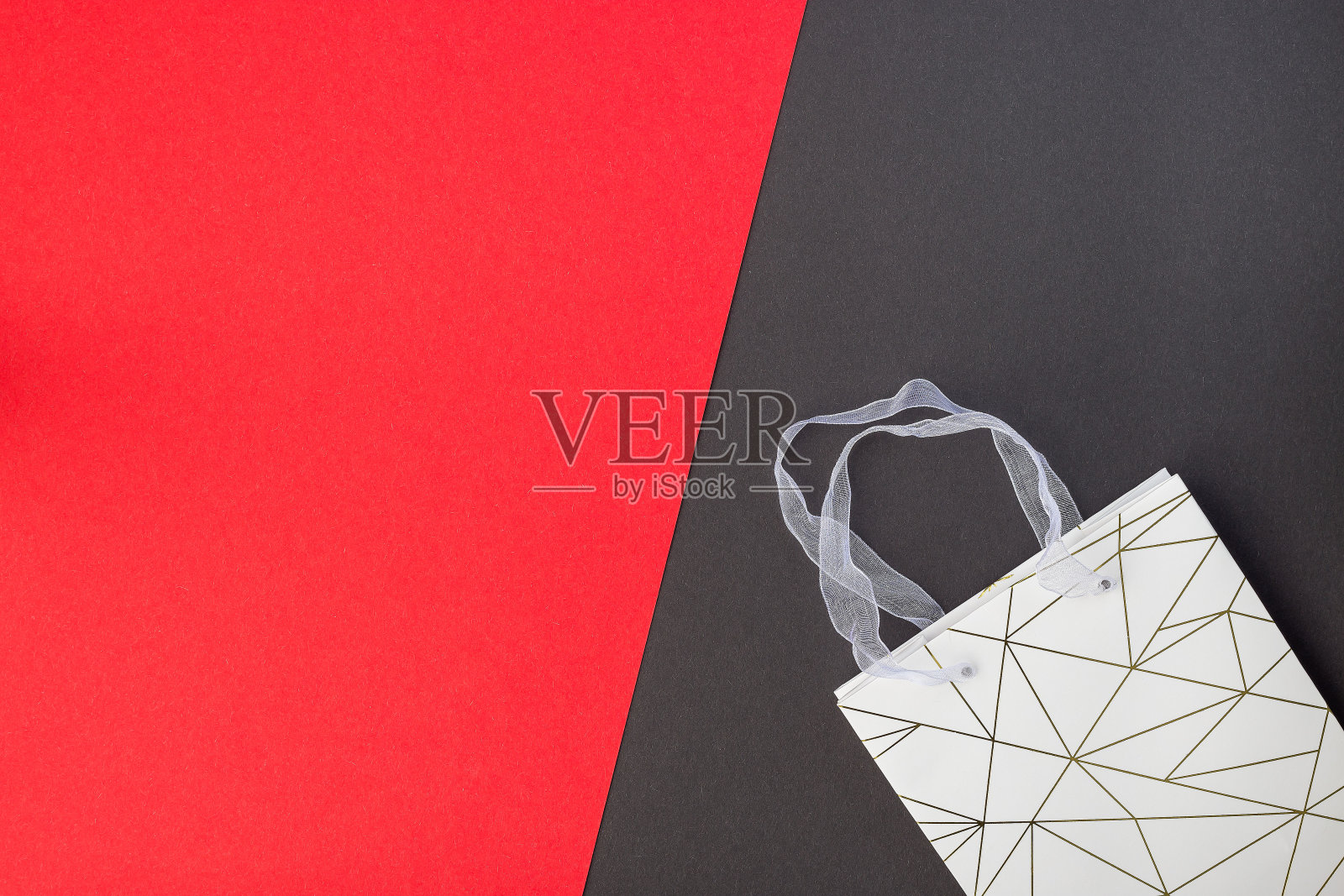 红色和黑色的纸纹理与纸质购物袋在上面,背景为模板,水平,复制空间照片摄影图片