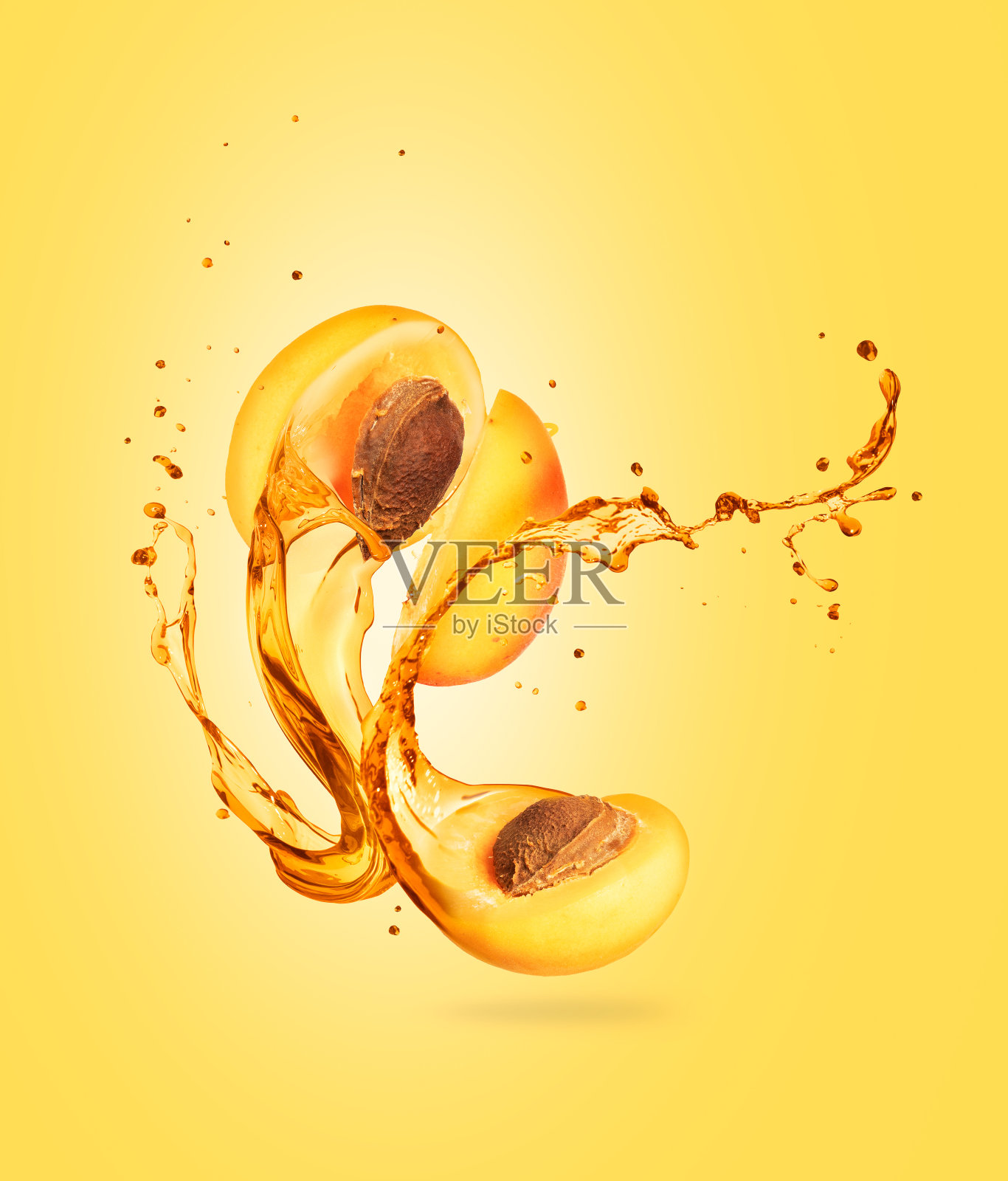 果汁从切好的杏子上溅落在黄色的背景上照片摄影图片