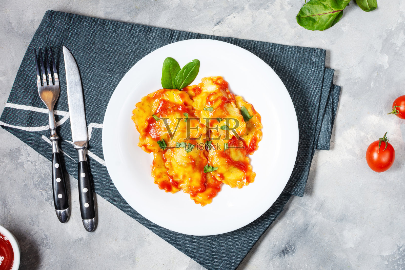 浇上番茄酱和罗勒的意大利饺子。美味的意大利面照片摄影图片