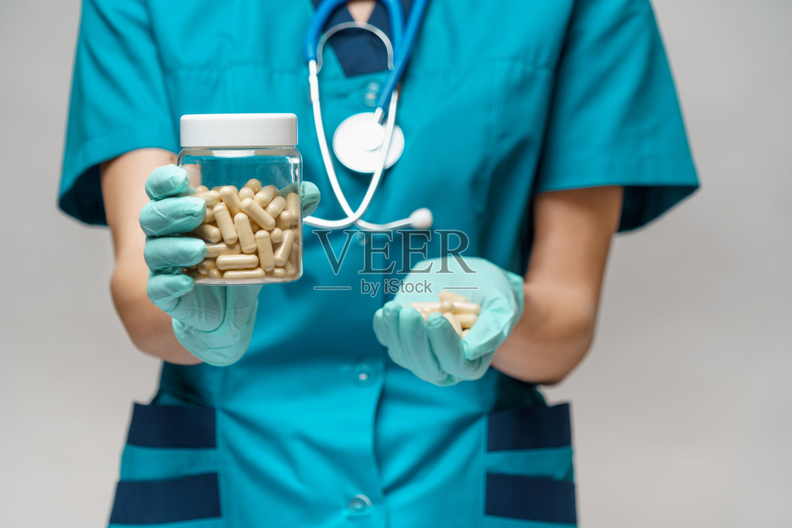 戴防护口罩和乳胶手套的女医生护士,手拿药丸照片摄影图片