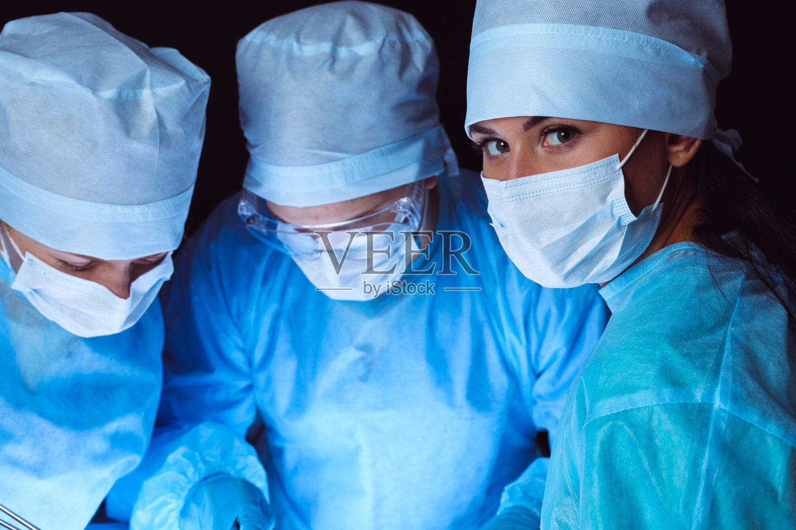 一组外科医生戴着安全口罩进行手术。医学的概念照片摄影图片