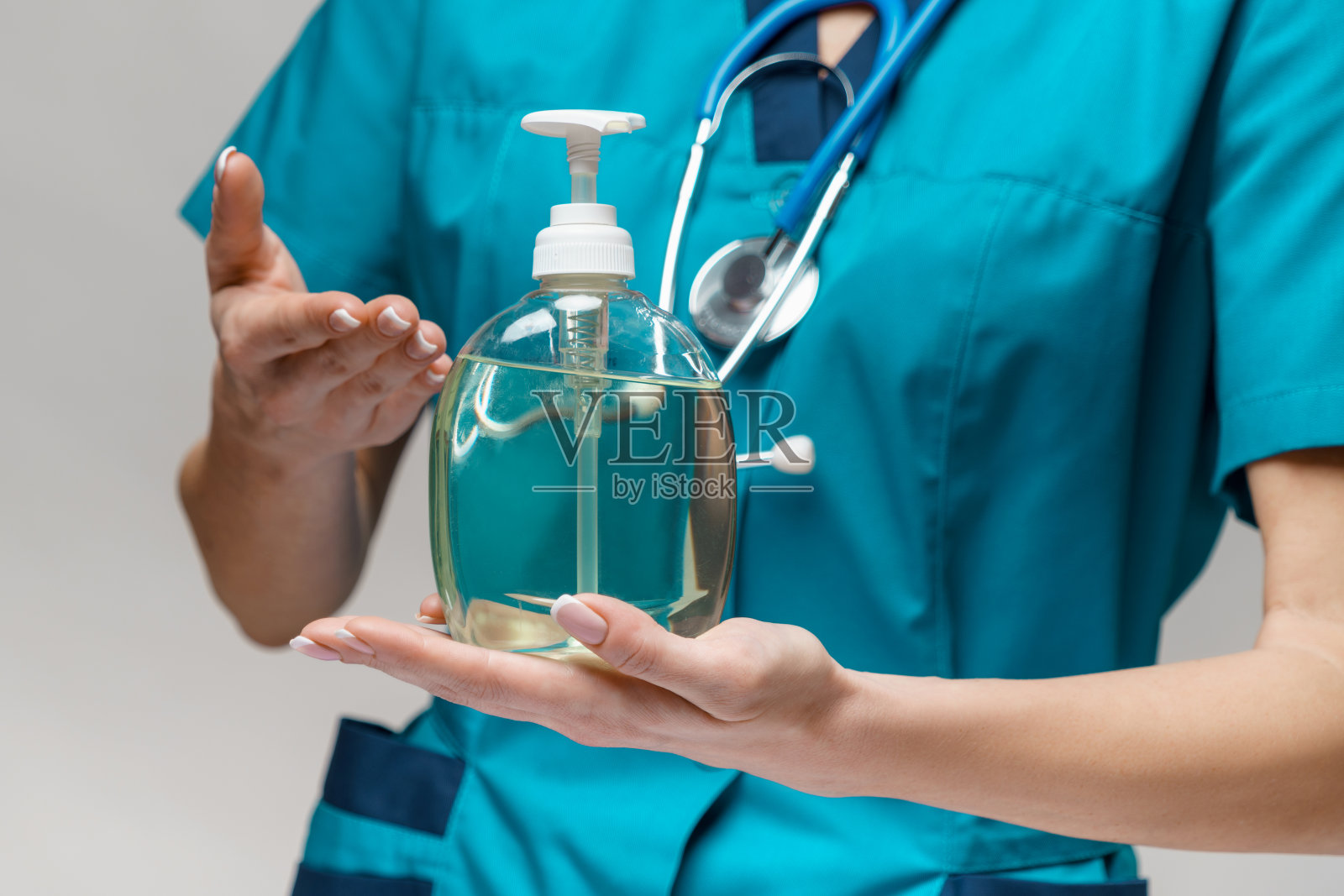 医护人员戴口罩持消毒液照片摄影图片