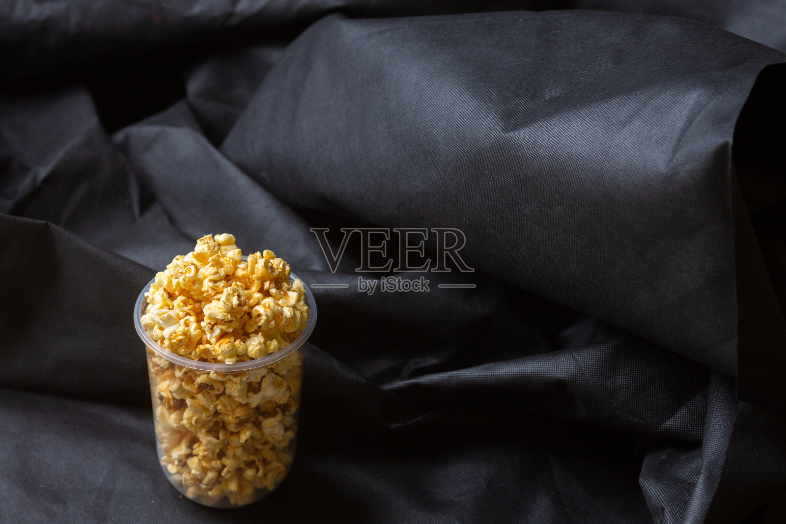 爆米花放在一个大桶里。照片摄影图片