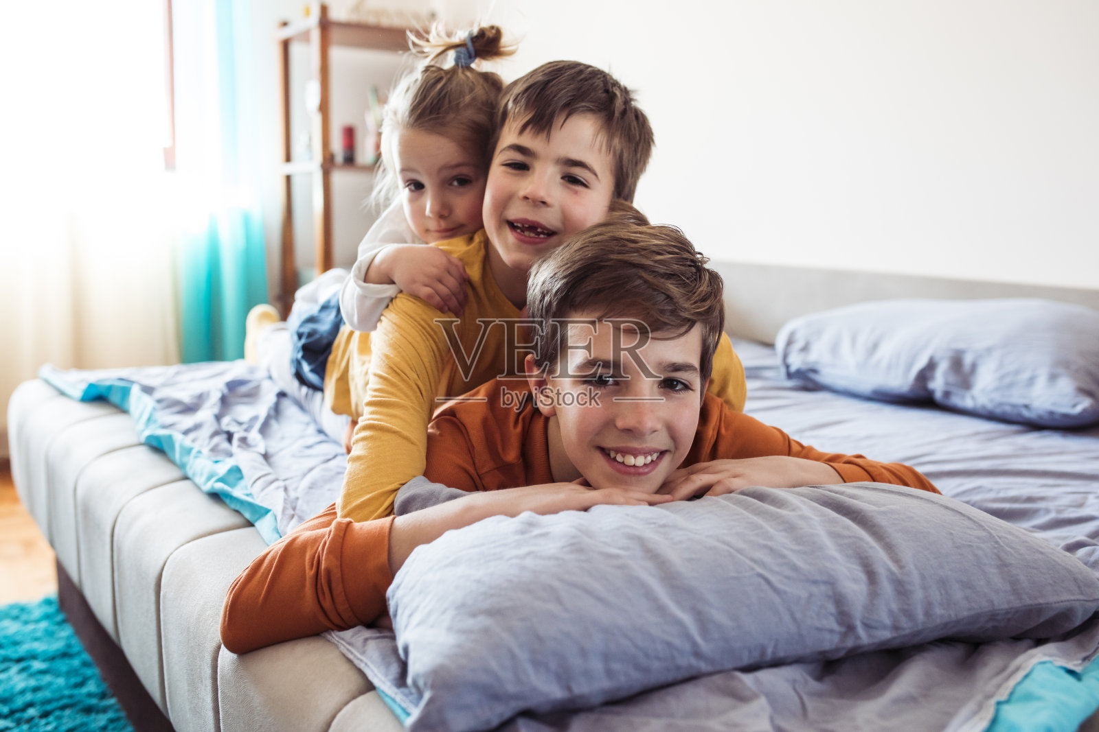 家里的孩子们一个一个躺在床上照片摄影图片