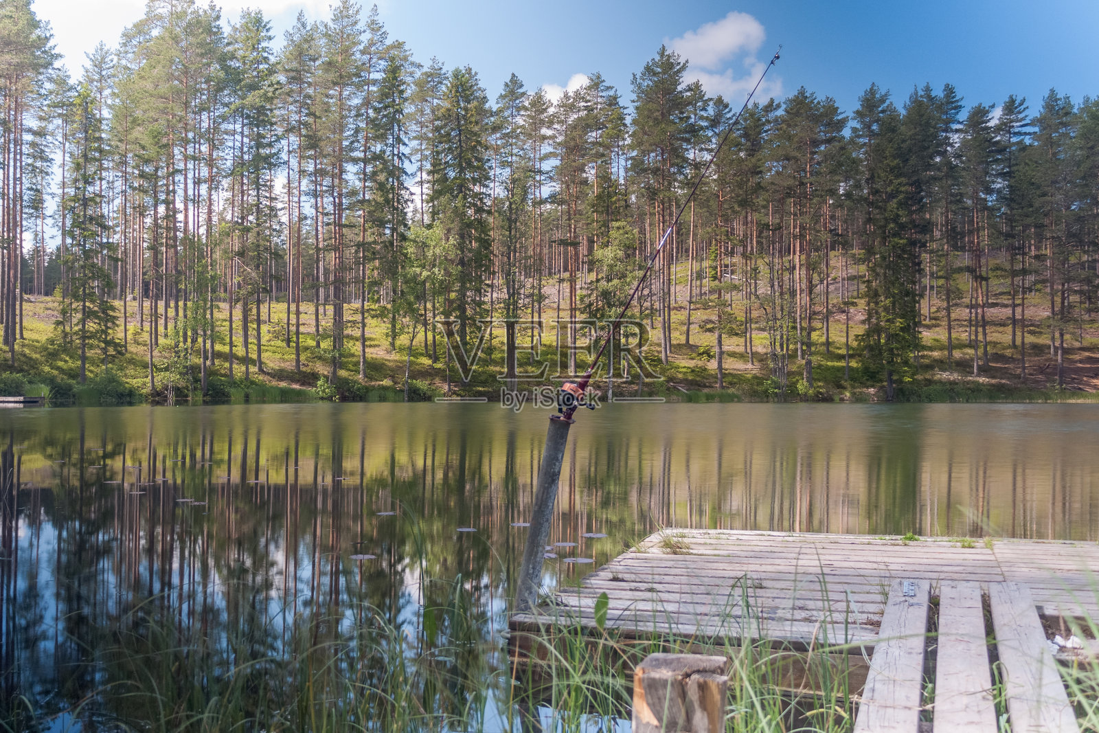鱼竿旋转,有线的特写镜头。鱼竿在码头上的鱼竿支架上。瑞典。有选择性的重点。长时间曝光照片摄影图片
