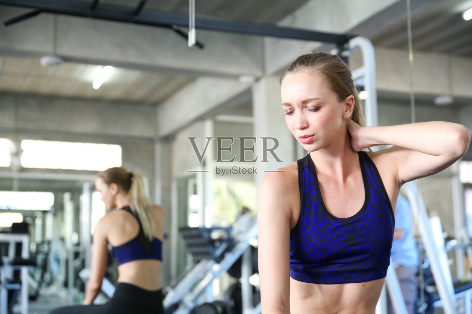 年轻女性正经历着过度运动带来的肌肉疼痛。照片摄影图片