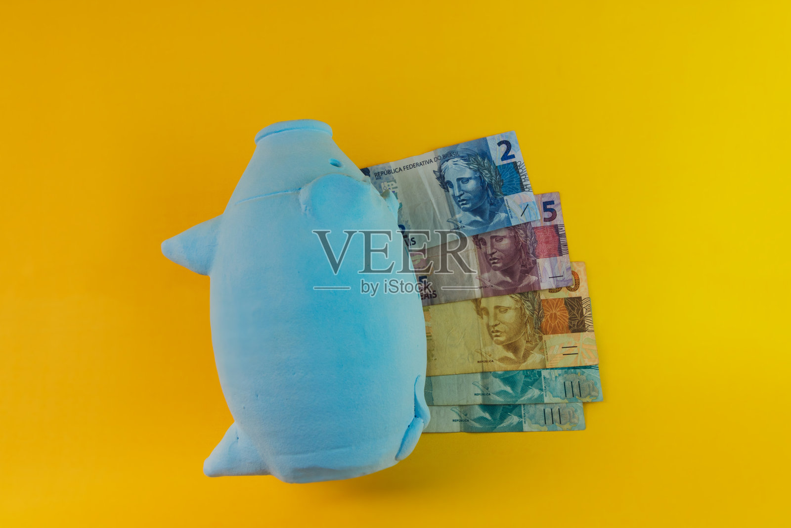 小猪硬币与计算器和巴西货币隔离照片摄影图片