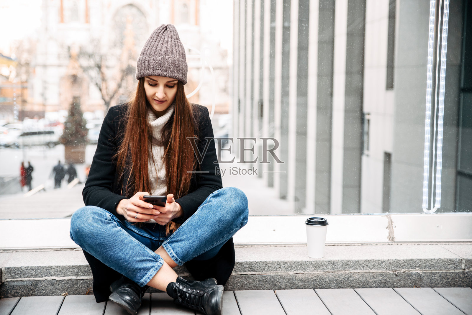 年轻迷人的女孩正在电话上输入信息照片摄影图片