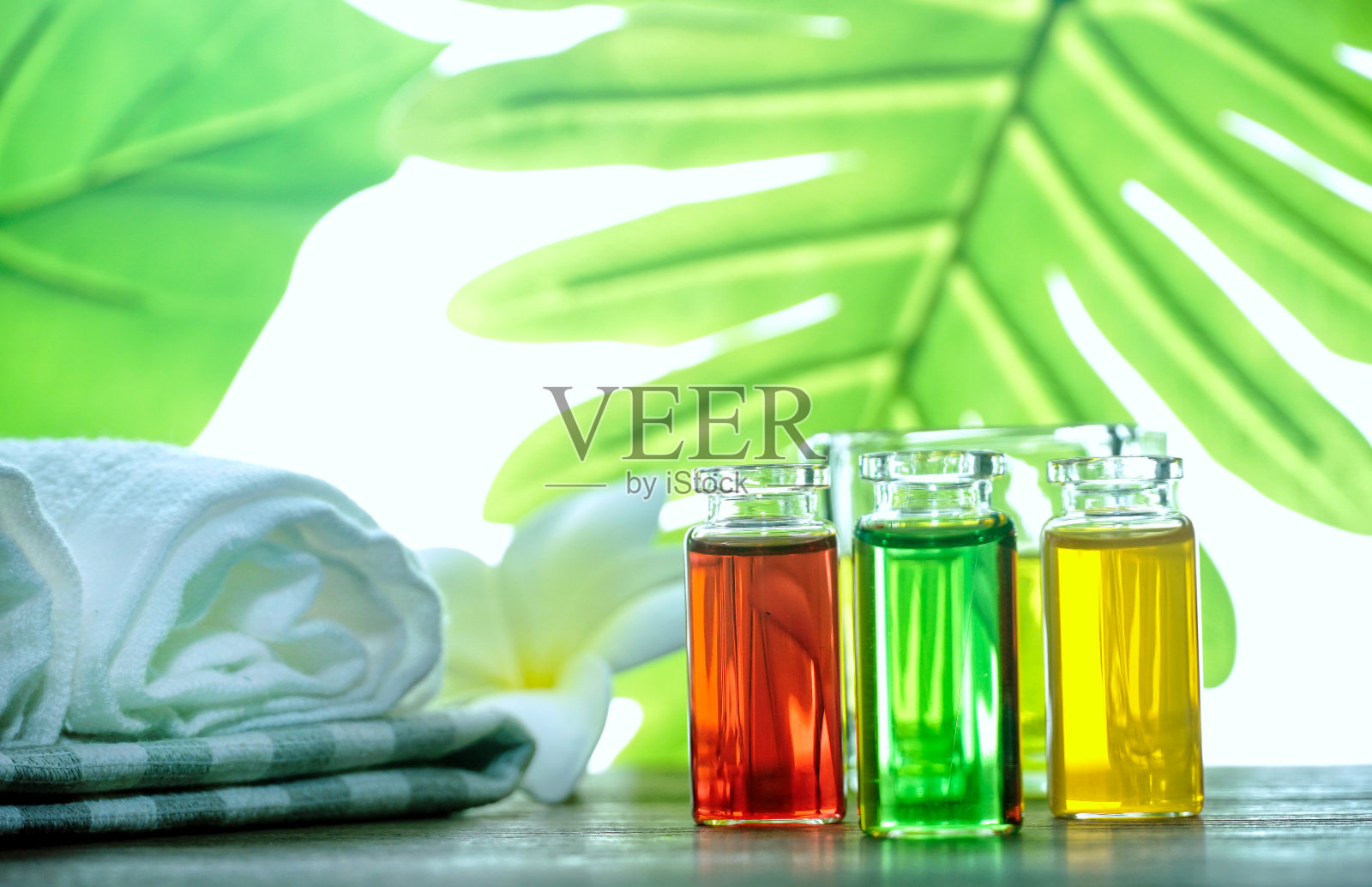 香油和液体肥皂在瓶子与spa设置在桌子上与背景绿色树叶靠近窗户,自我护理的概念。照片摄影图片