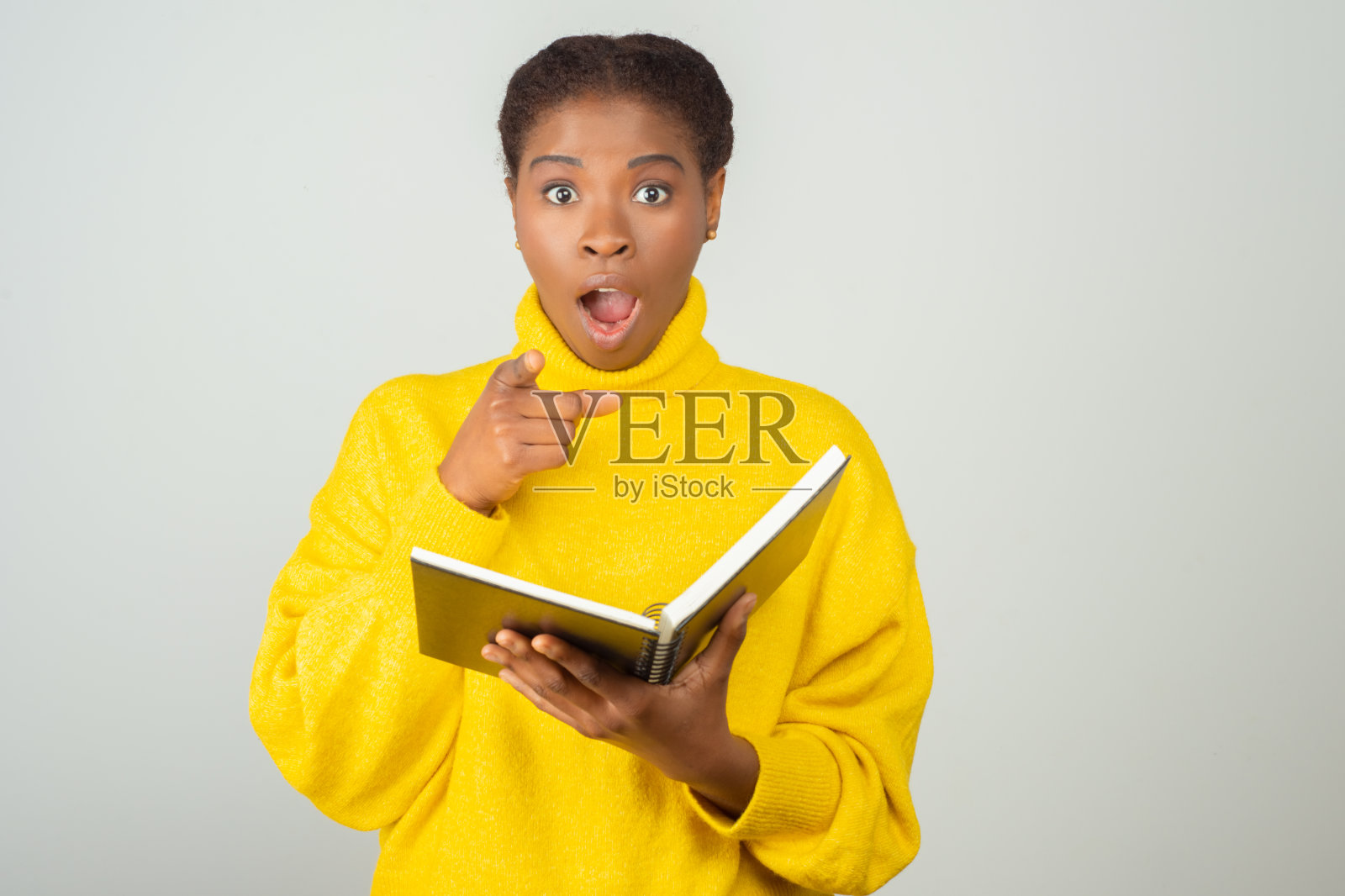 震惊兴奋的黑人妇女拿着记事本照片摄影图片