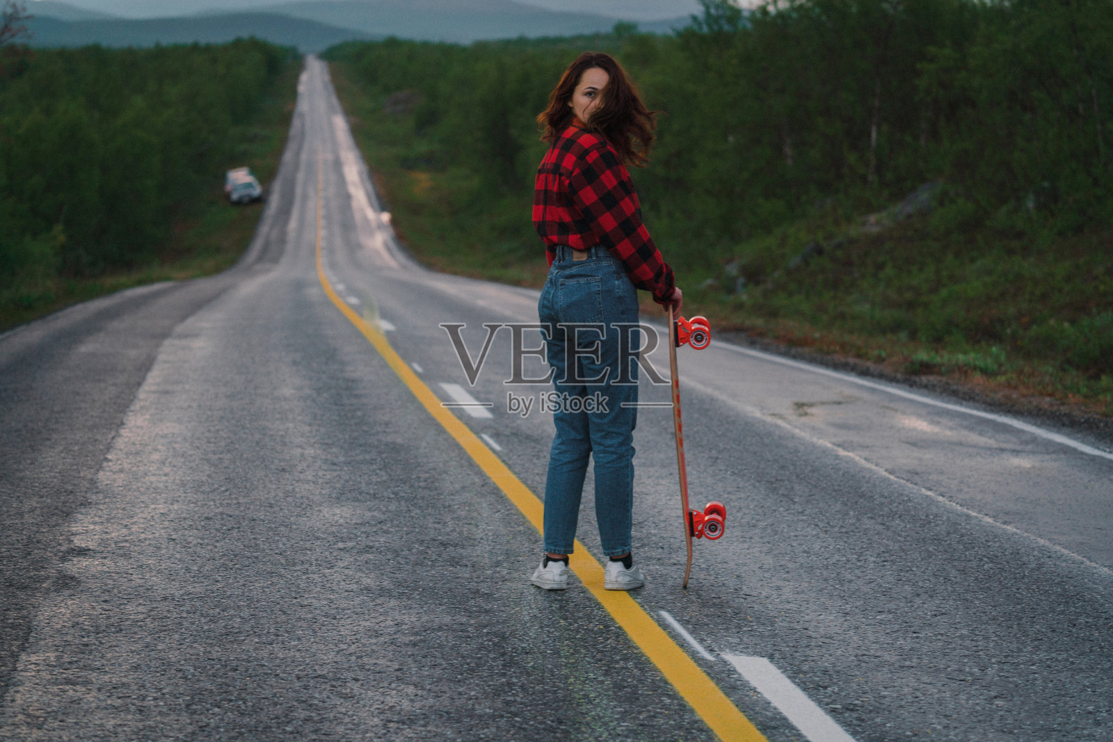 芬兰的一名女子在路上玩长滑板照片摄影图片