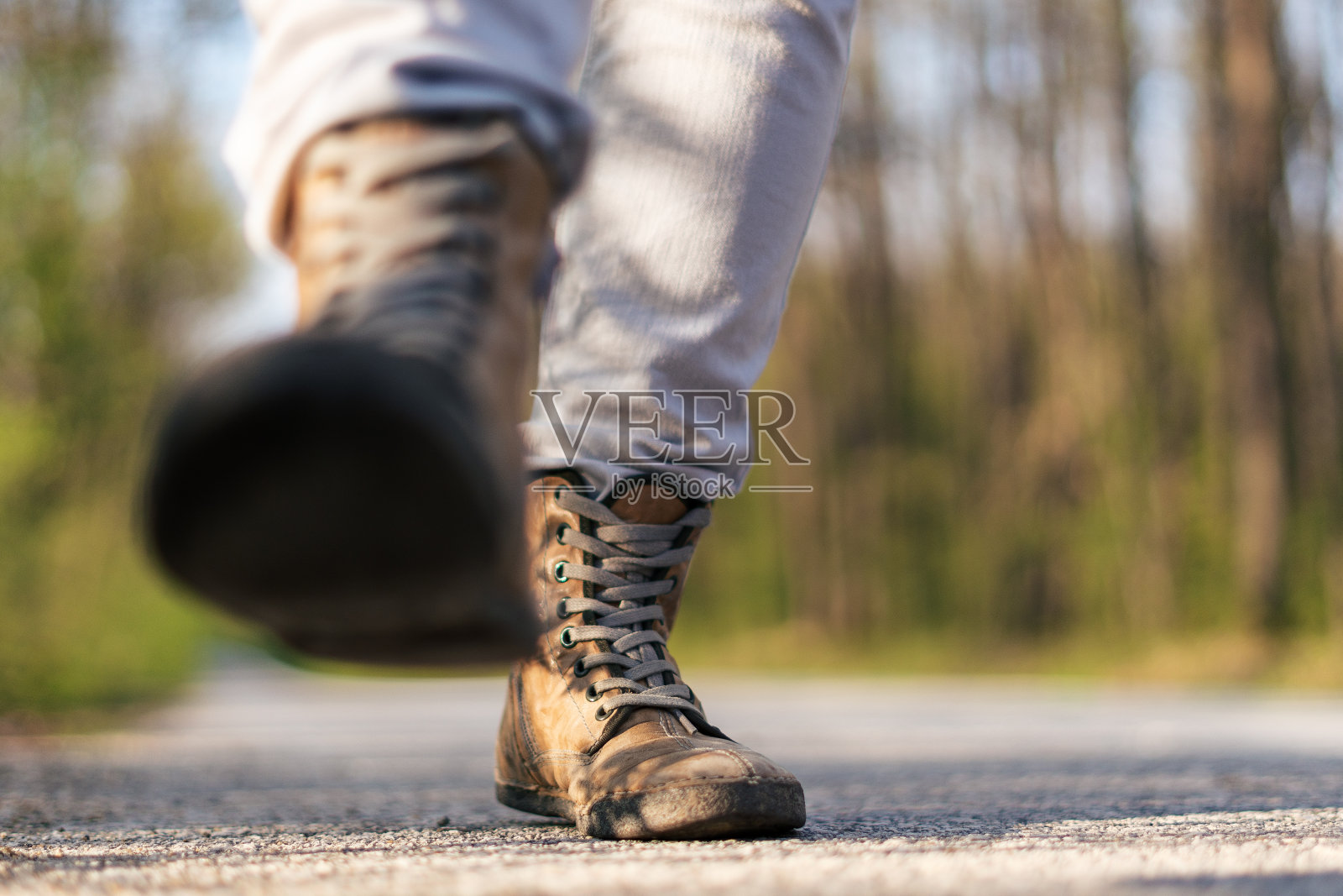 搭便车旅行的嬉皮女人。脚在路上。照片摄影图片