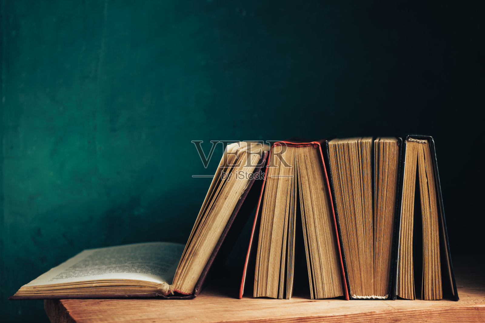 漂亮的古书。图案背景设计。书放在红色的木桌和绿色的墙壁上。照片摄影图片