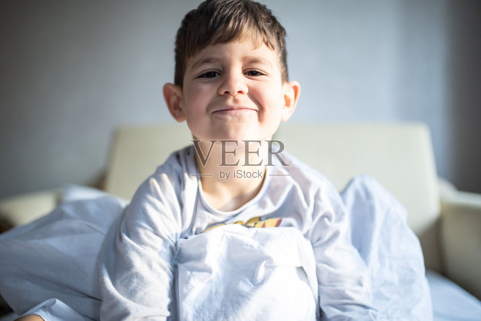 一个可爱的男孩在床单库存照片照片摄影图片