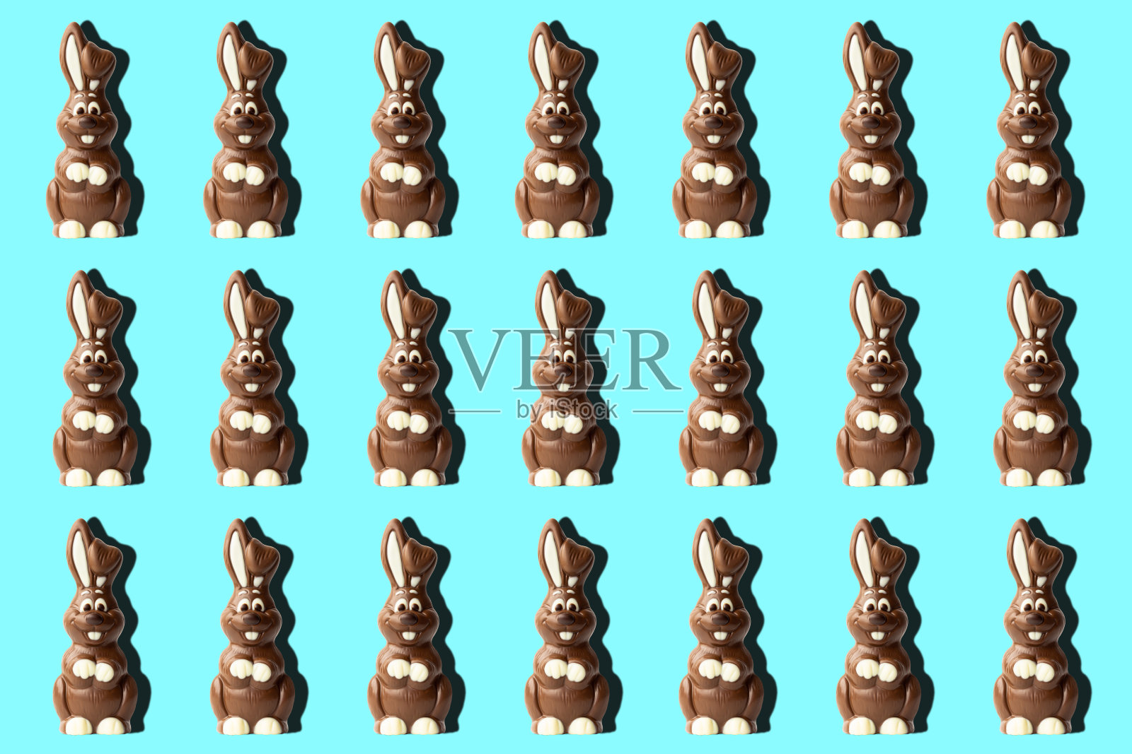 时髦的复活节图案,巧克力兔子在浅蓝色的背景在最小的风格。照片摄影图片