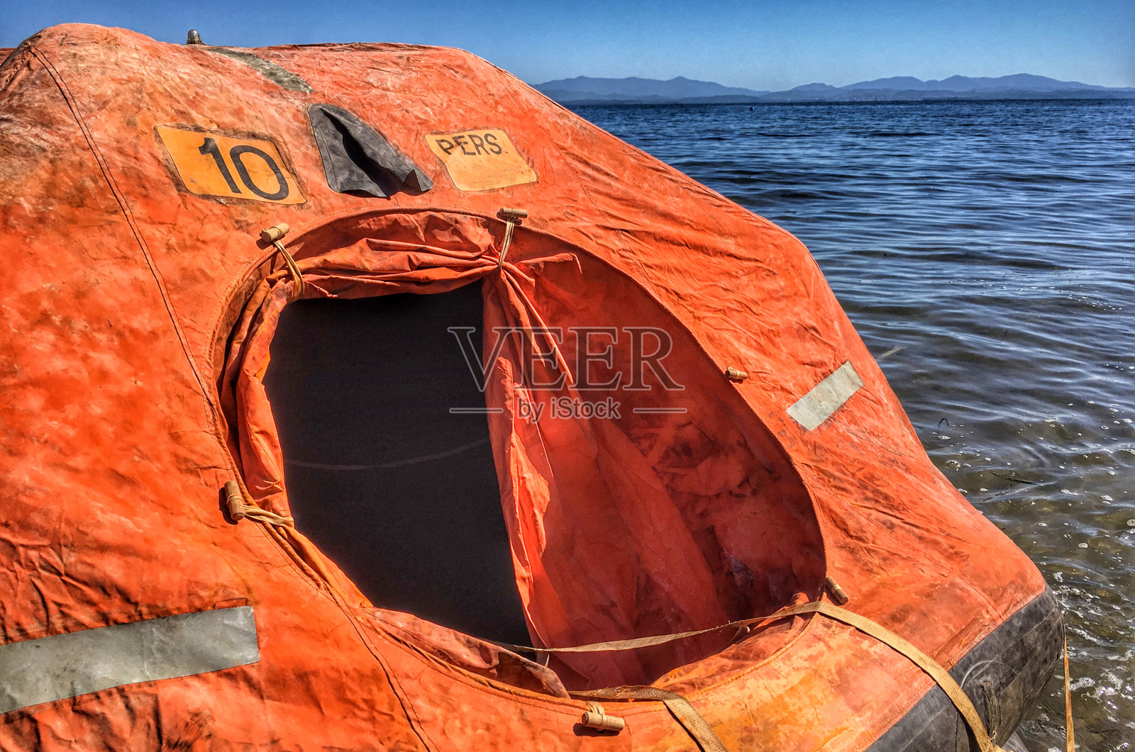 一只漂浮在海上的小救生筏。照片摄影图片