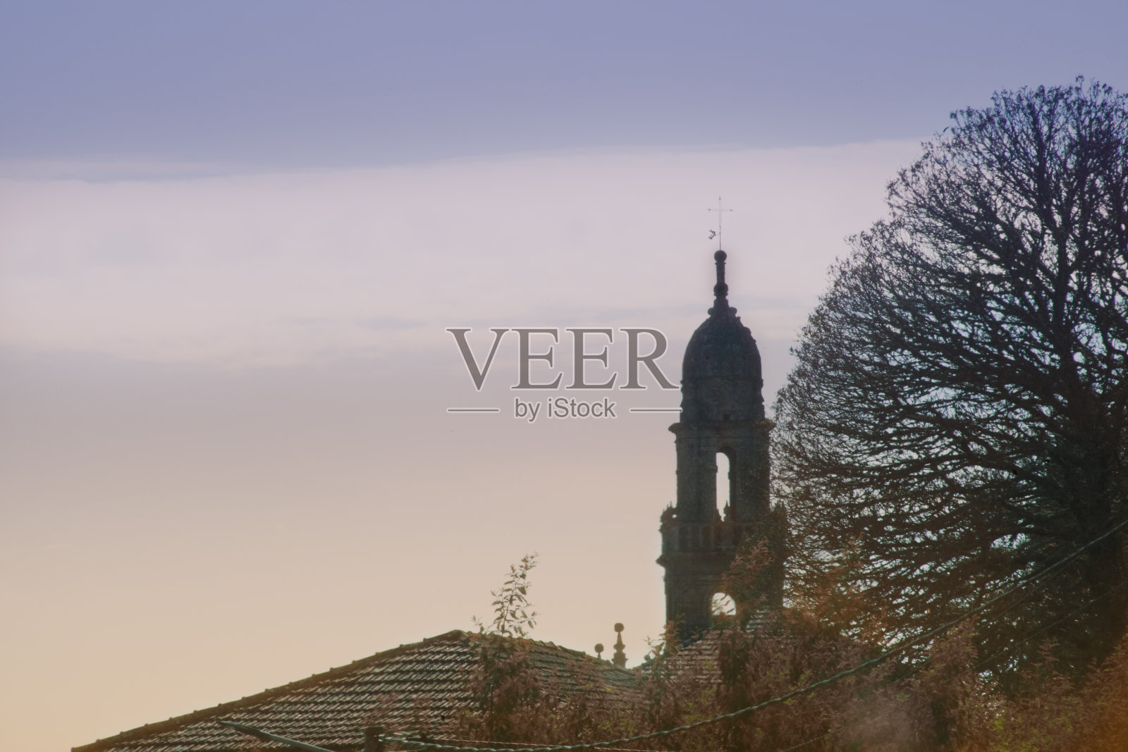 教堂,钟楼,光秃秃的树和夕阳照片摄影图片