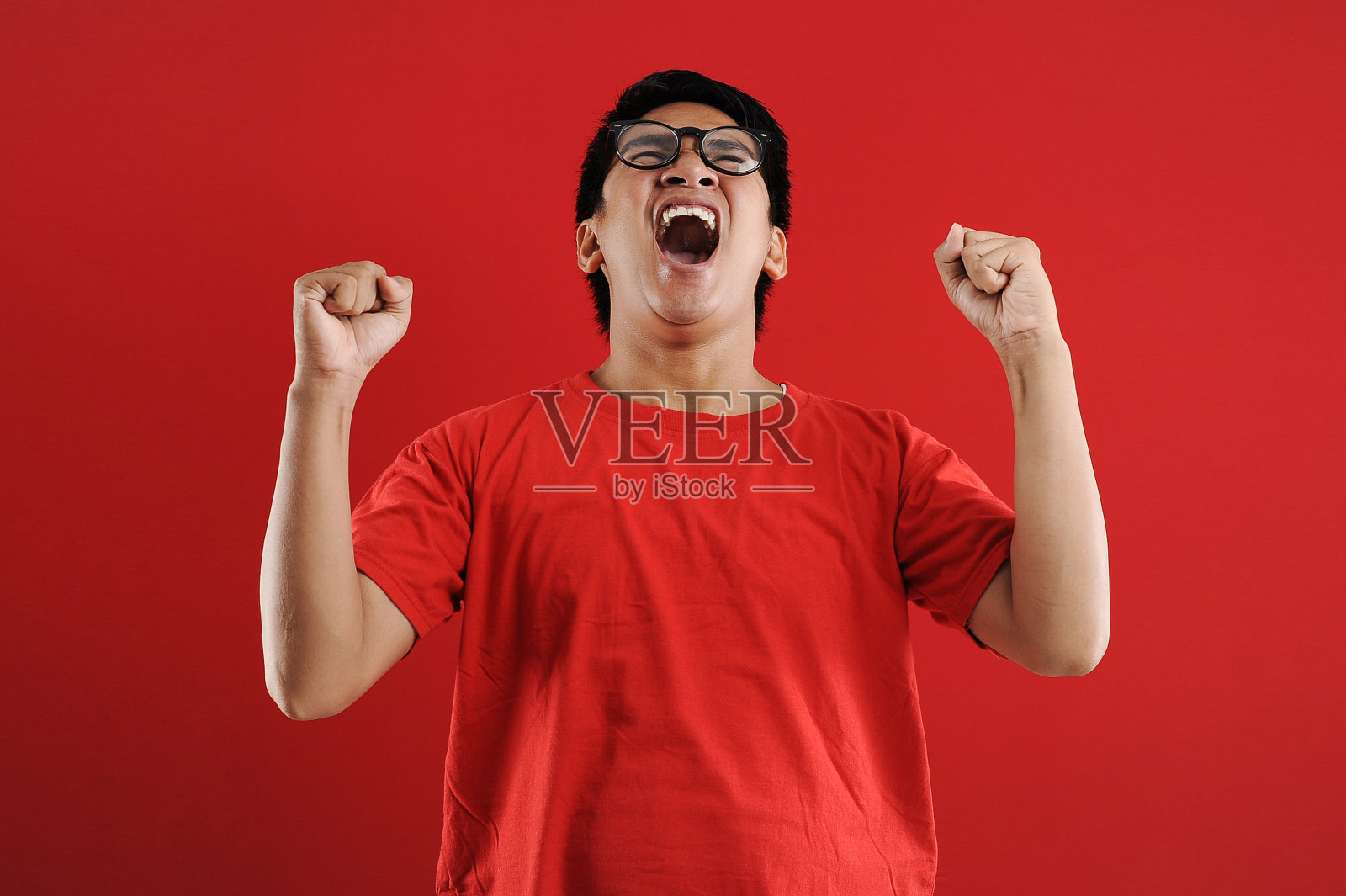 年轻的亚洲男子高兴和兴奋表达获胜的姿态。成功和庆祝照片摄影图片