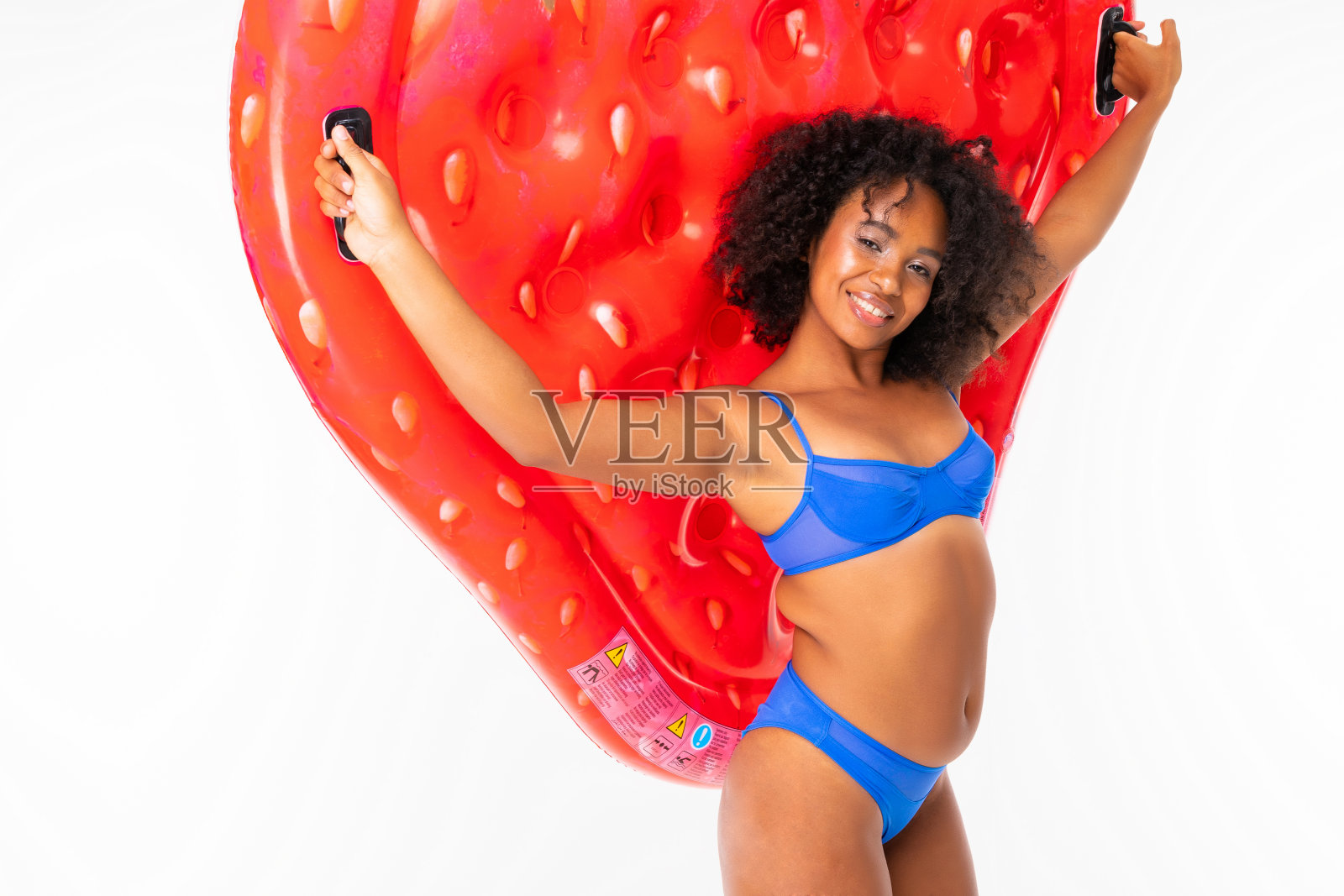 性感的非洲女孩在一个白色孤立的背景上,与明亮的空气床垫照片摄影图片