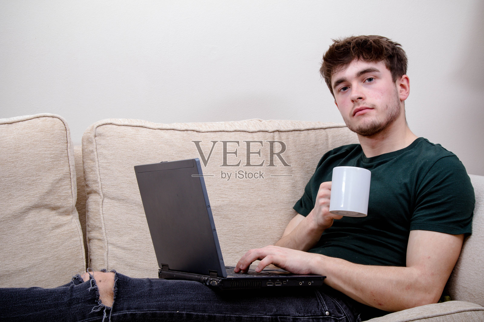 一个年轻人坐在沙发上照片摄影图片