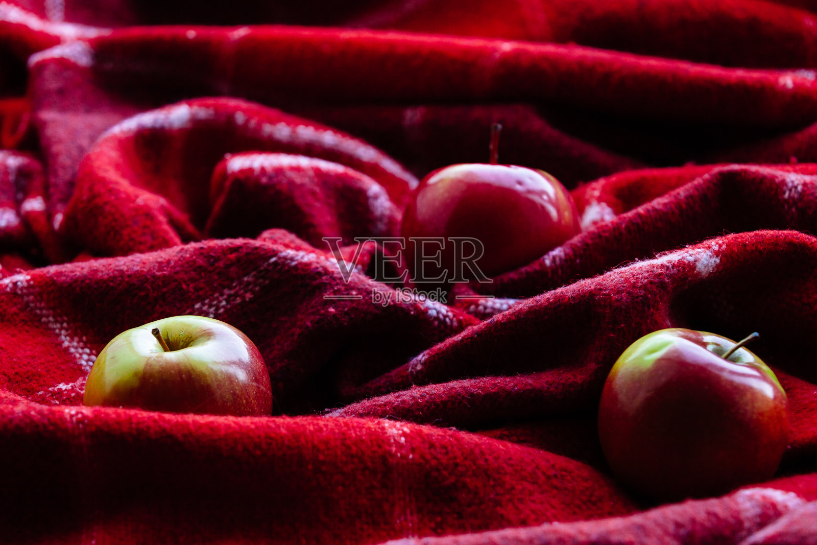 阳光下的格子图案上的成熟苹果照片摄影图片