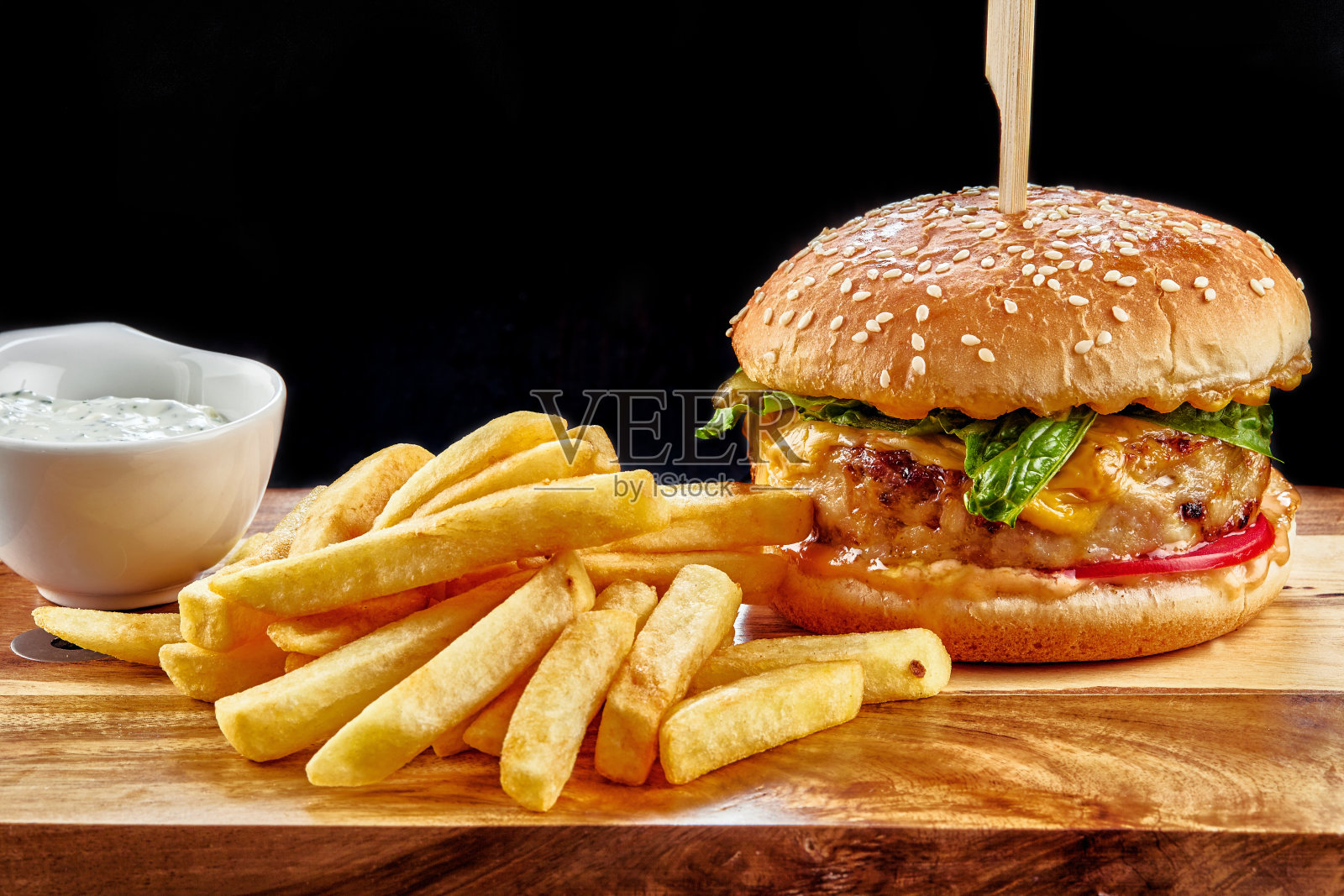 一个汉堡坐在木桌上的特写照片摄影图片