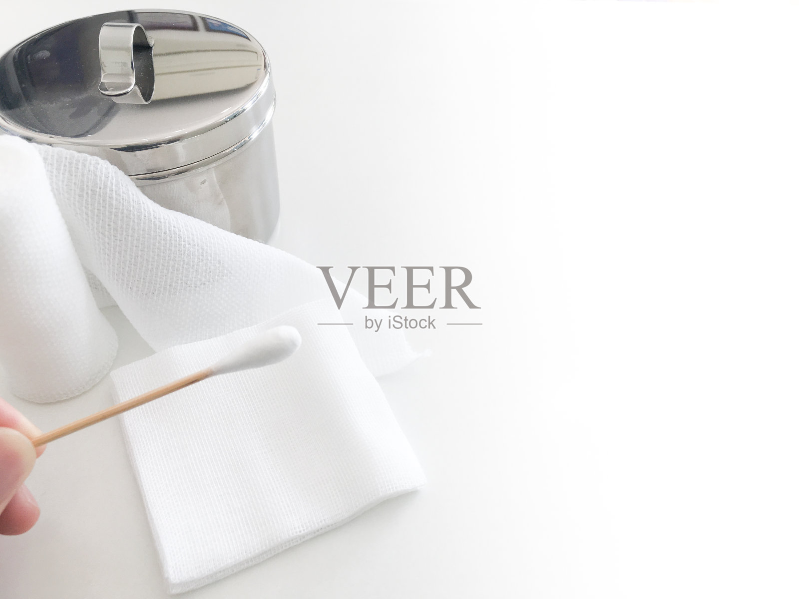 指尖握住棉签与卷纱布和纱布罐与拷贝空间照片摄影图片