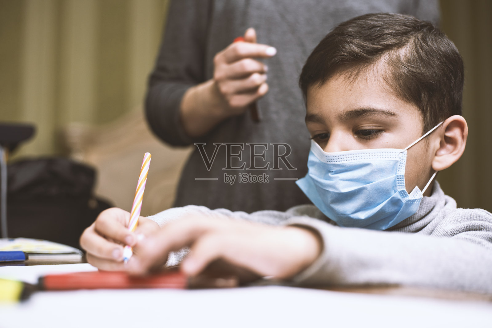 远程教育。母亲帮助学龄前儿童完成课程照片摄影图片