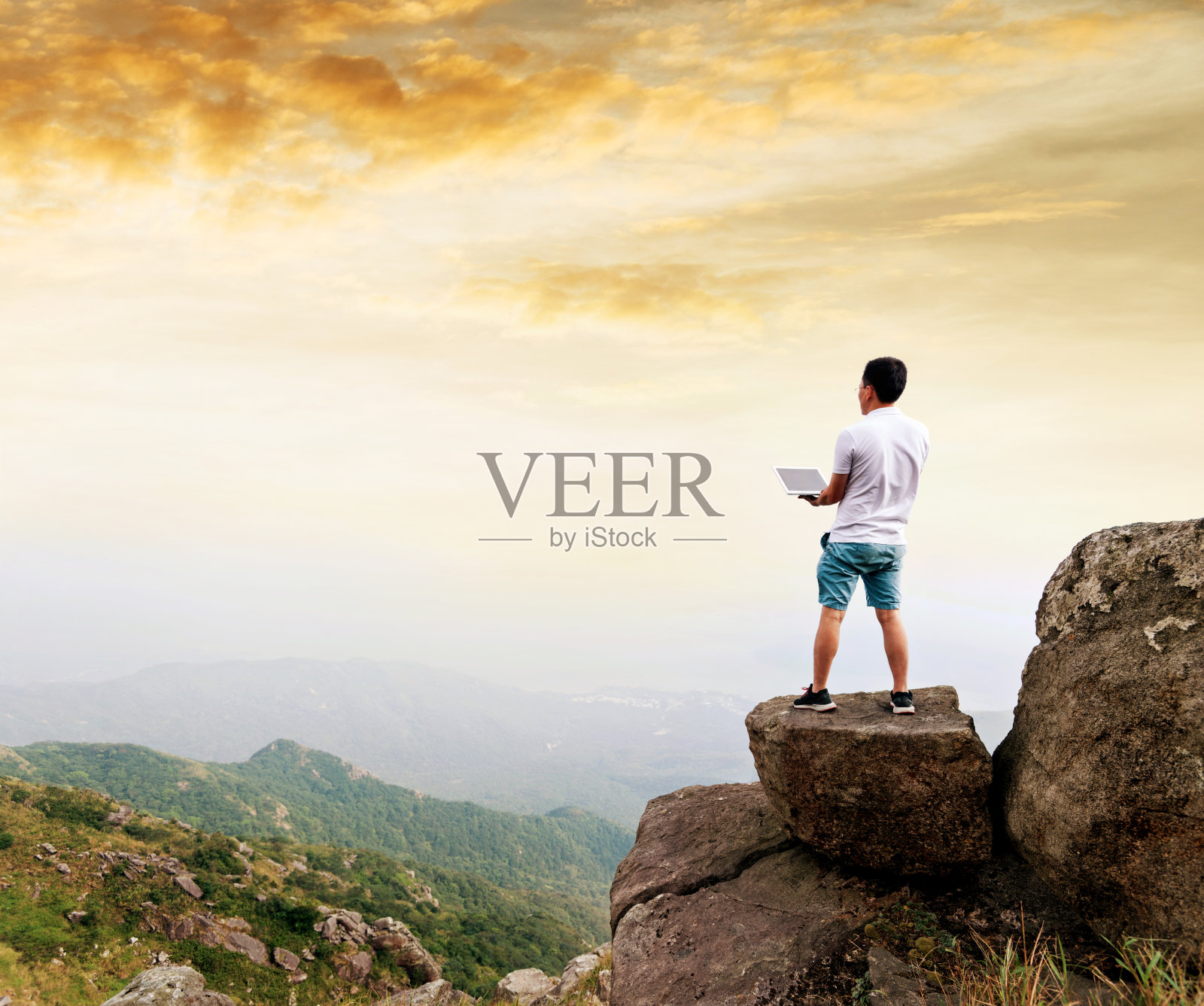 在山顶上用笔记本电脑的人照片摄影图片