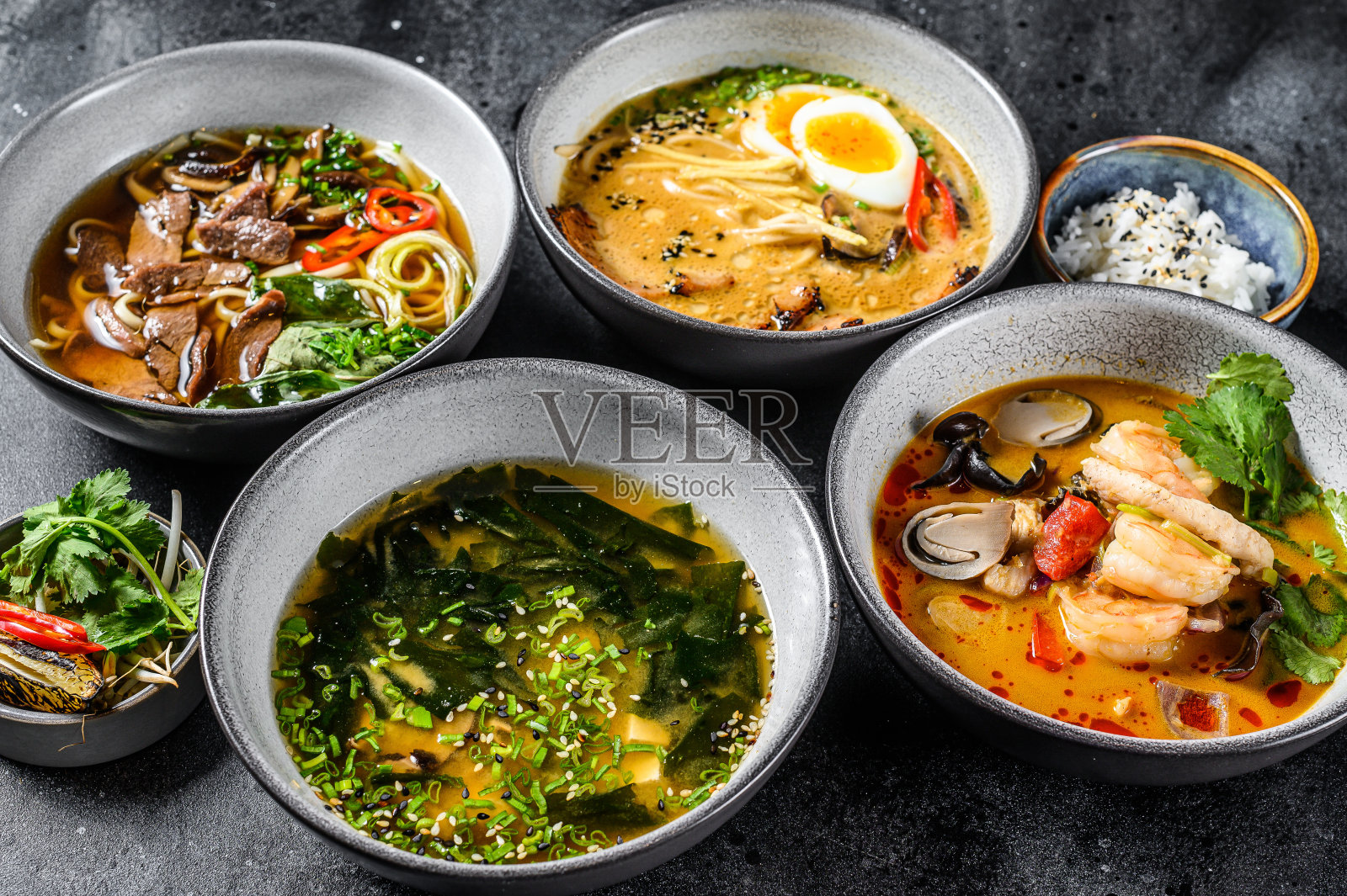 混合传统亚洲汤。味噌、拉面、冬阴粉、粉婆。黑色背景。俯视图照片摄影图片