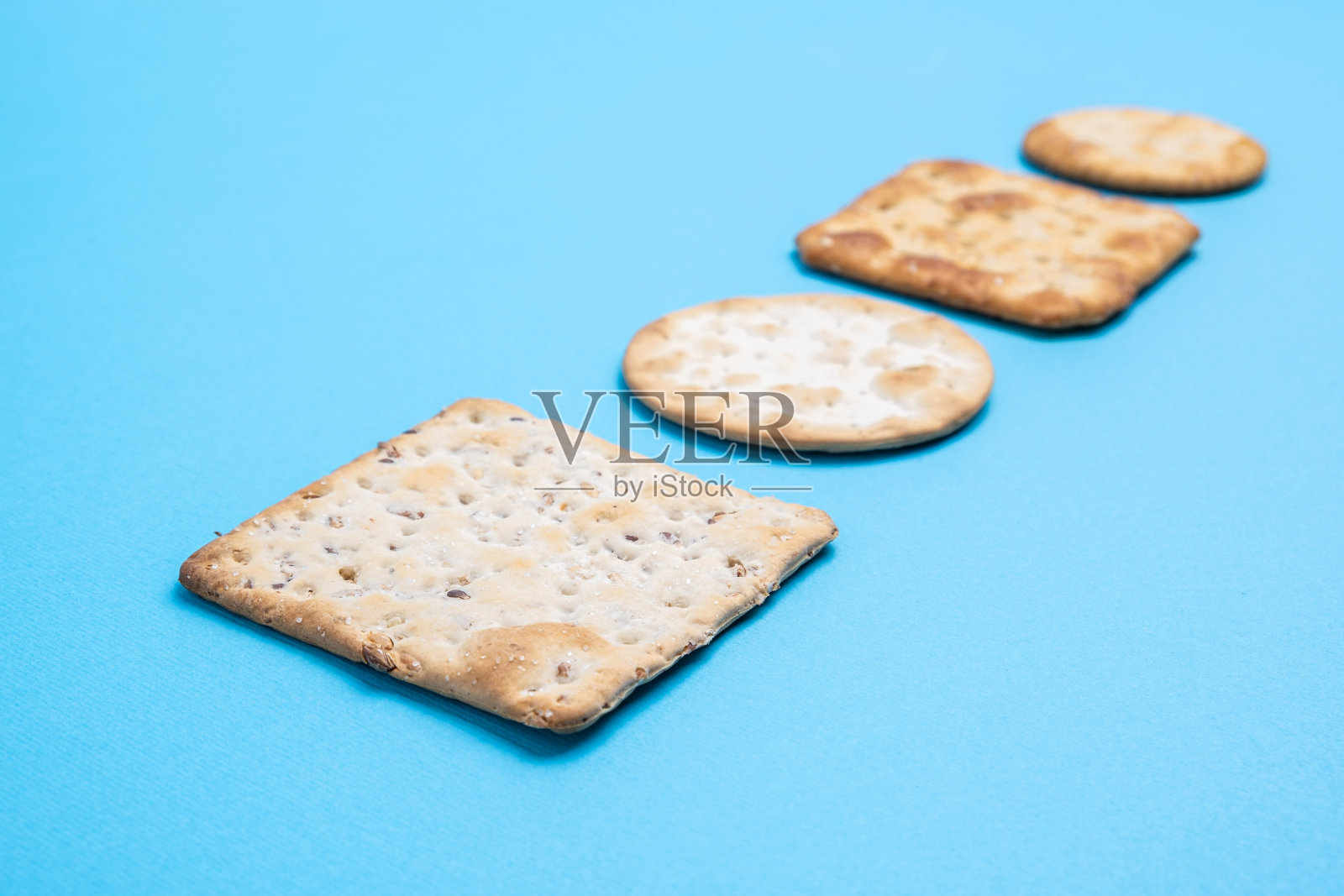 在浅焦点透视下的蓝色背景上的饼干照片摄影图片