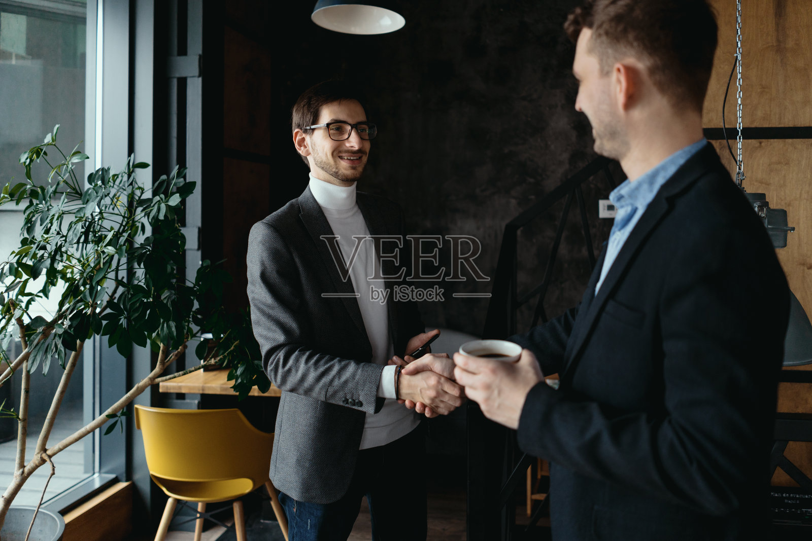 两个年轻的商人互相问候,握手照片摄影图片