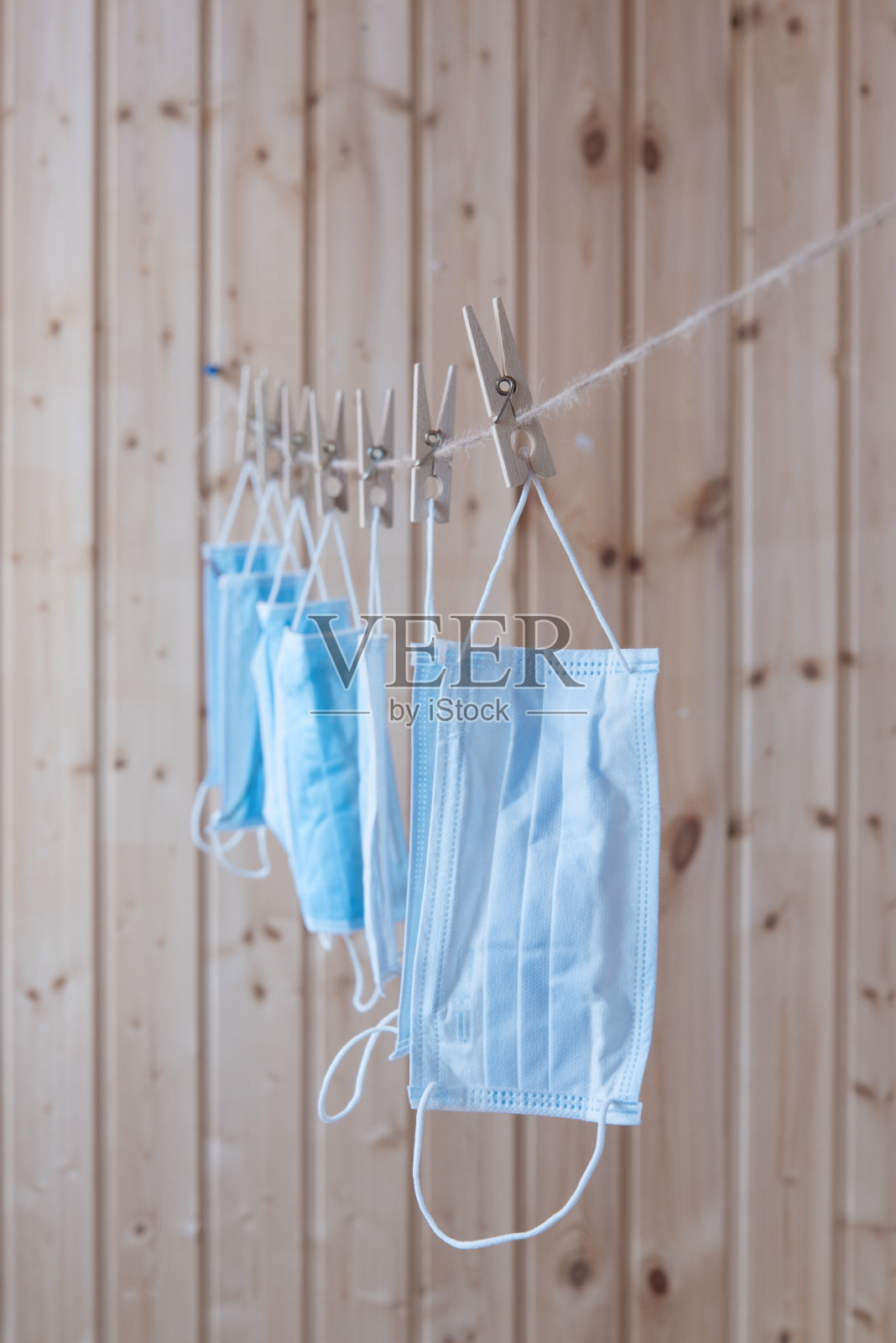 一次性医用口罩挂在晾衣绳上。的概念。重用。赤字照片摄影图片