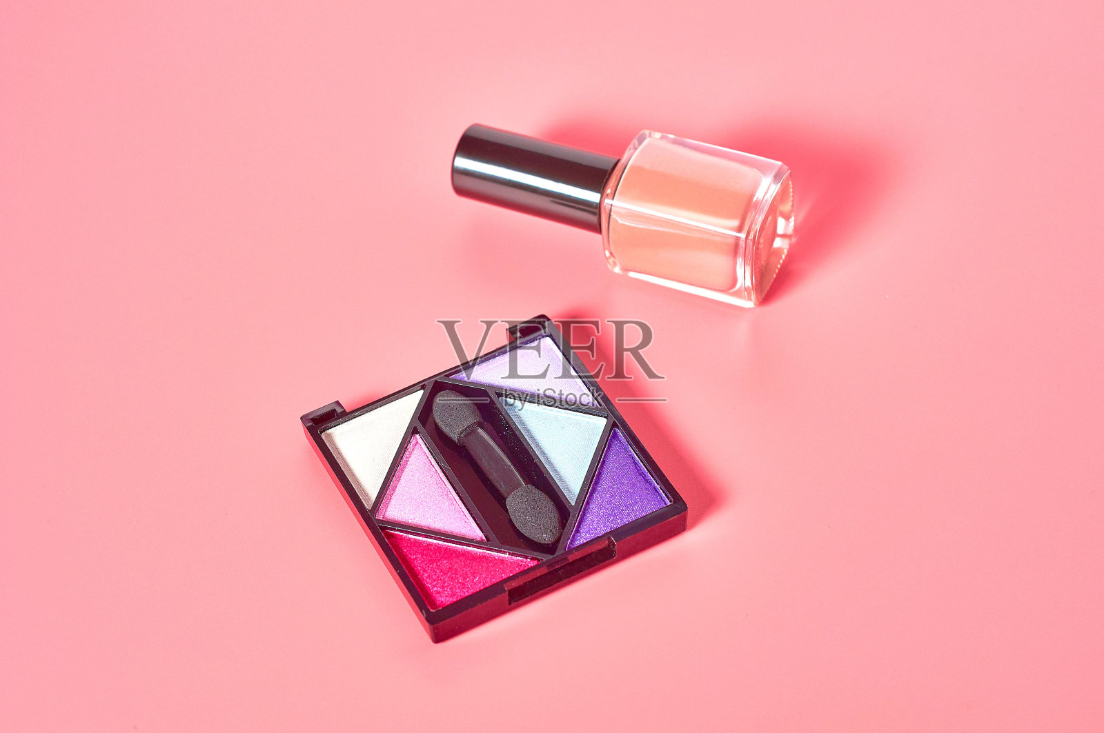 由指甲油附近的天然成分制成的色彩斑斓的腮红放在沙龙的粉色台面上。美丽和时尚的概念。脸护理照片摄影图片