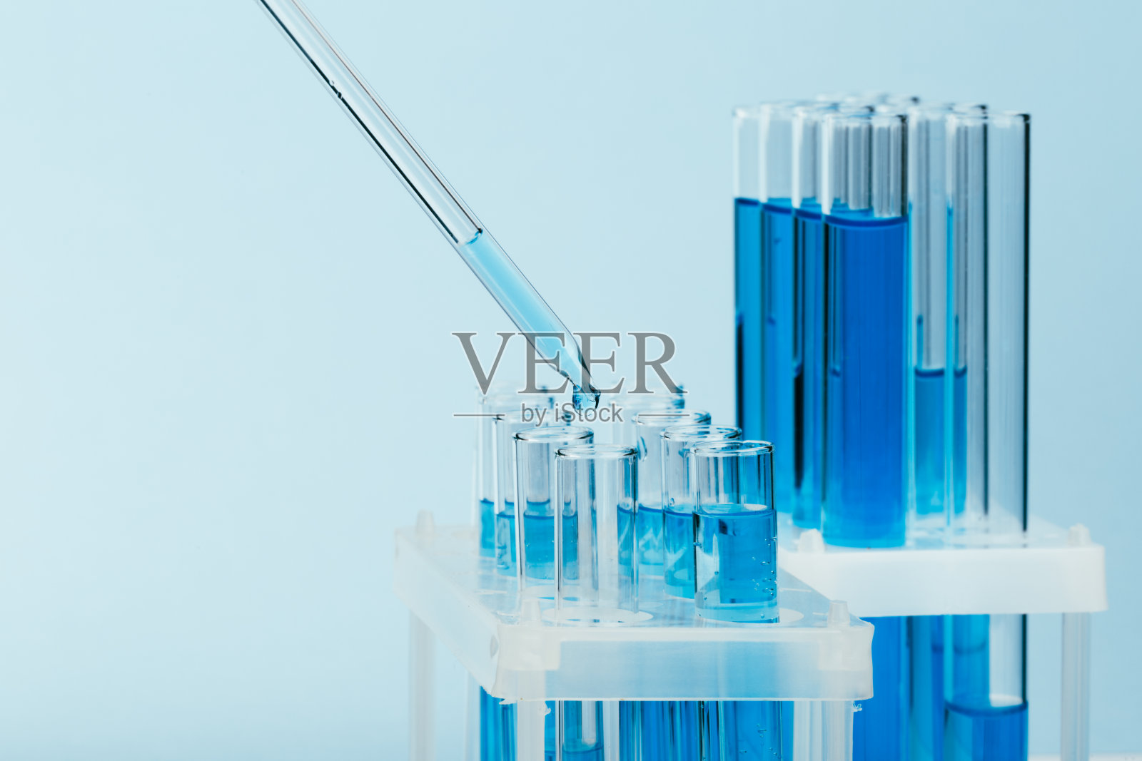 用滴管将液体滴入试管的实验室玻璃器皿。科学实验室试管,实验室设备照片摄影图片