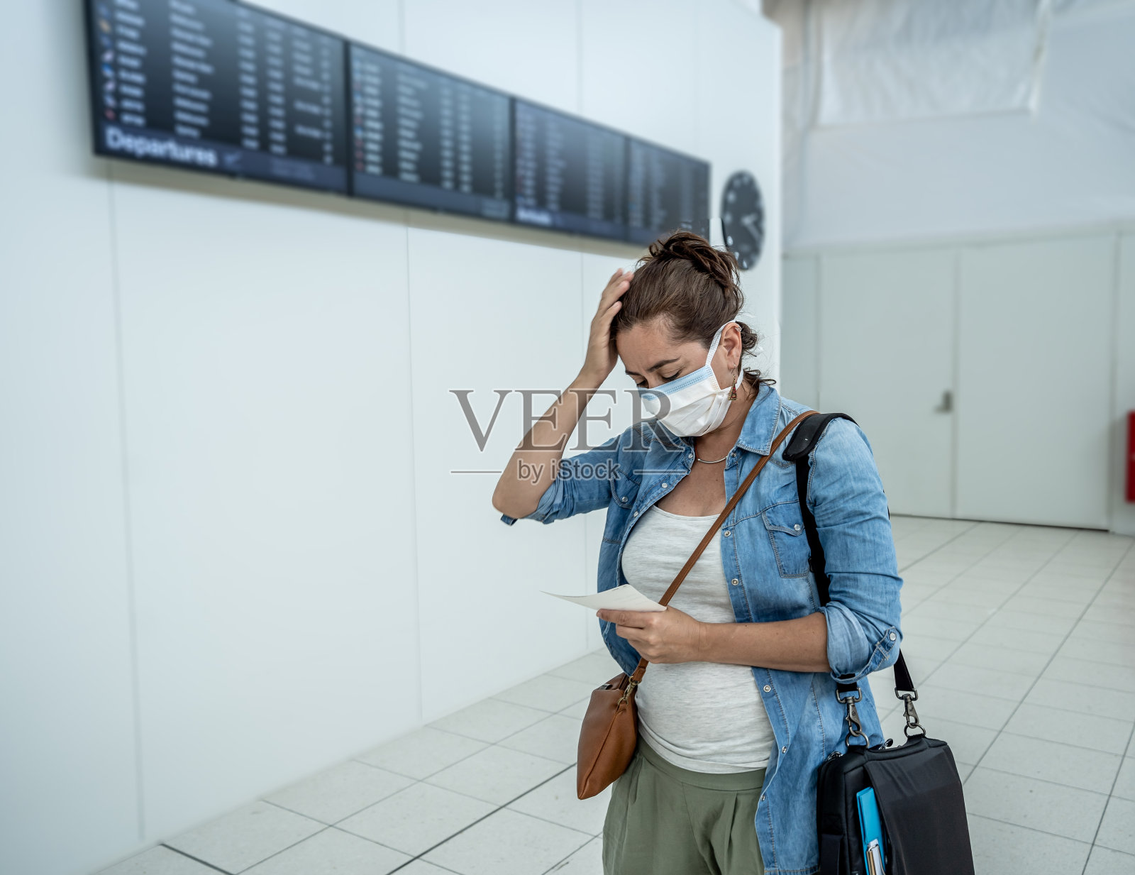 COVID-19全球边境关闭。戴着口罩的旅客在被拒绝进入其他国家后被困在机场候机楼。乘客在回国途中被困机场。照片摄影图片