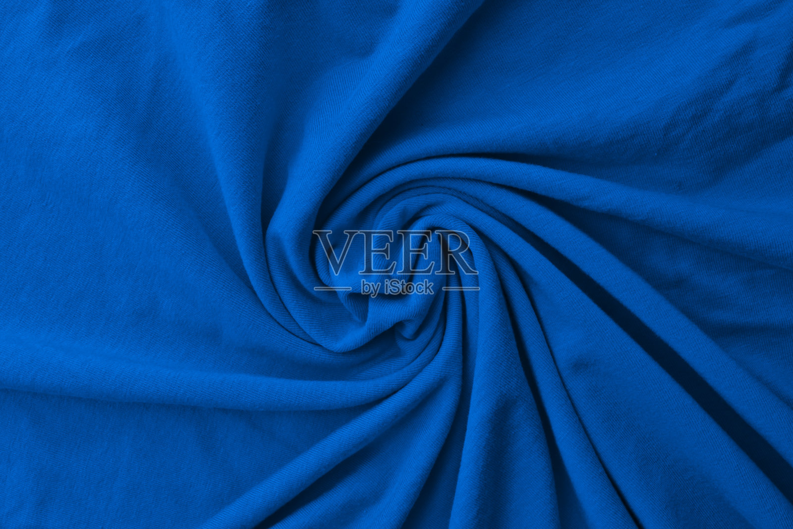 经典的蓝色精致织物褶皱和纺纱。特写镜头。照片摄影图片