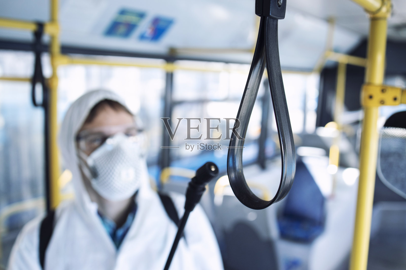 对公共汽车乘客把手进行消毒,防止高传染性冠状病毒或新冠肺炎的传播。照片摄影图片