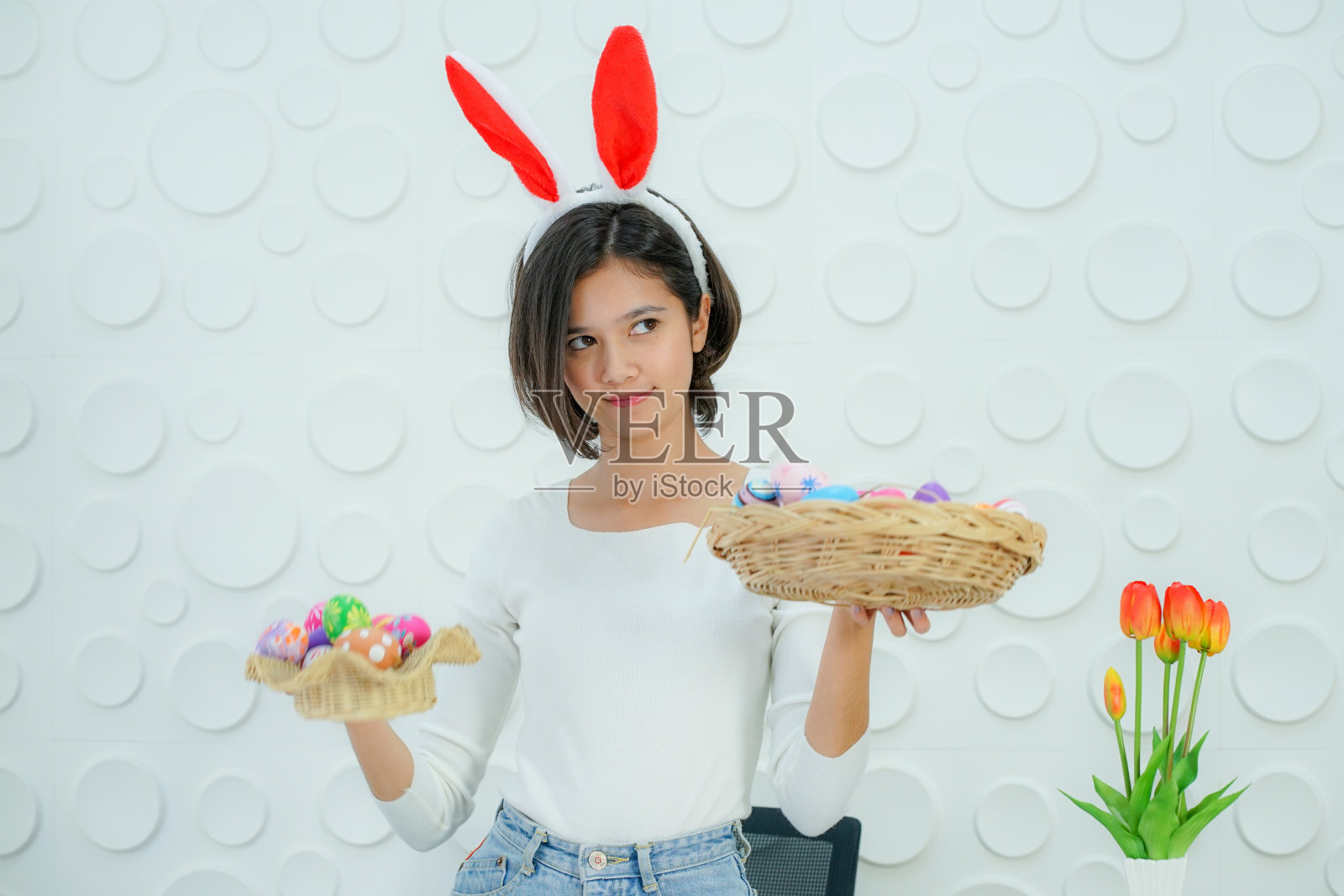 2019冠状病毒病(COVID-19)大流行居家隔离期间,亚洲短发少女在家中绘制复活节彩蛋照片摄影图片